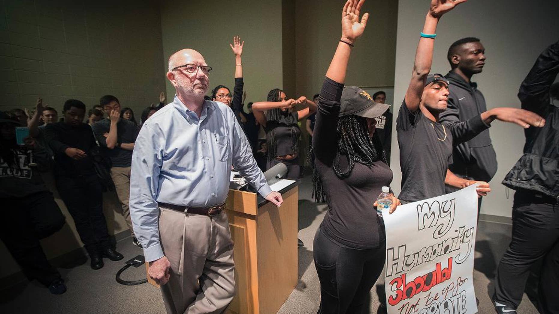 St. Olaf College President David R. Anderson is surrounded by student protesters in the Tomson Hall auditorium on campus in Northfield, Minn. May 1, 2017
