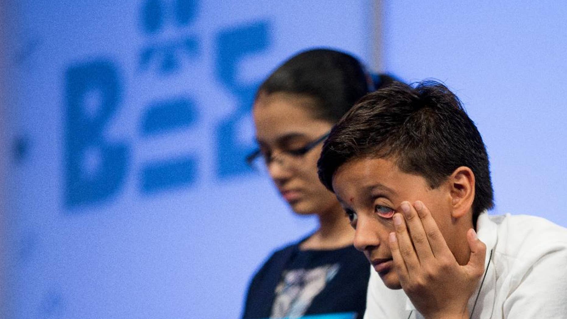 Jairam Hathwar, 12, of Corning, N.Y., right, sits on stage during the semifinals of the Scripps National Spelling Bee, Thursday, May 28, 2015, in Oxon Hill, Md. (AP Photo/Andrew Harnik)