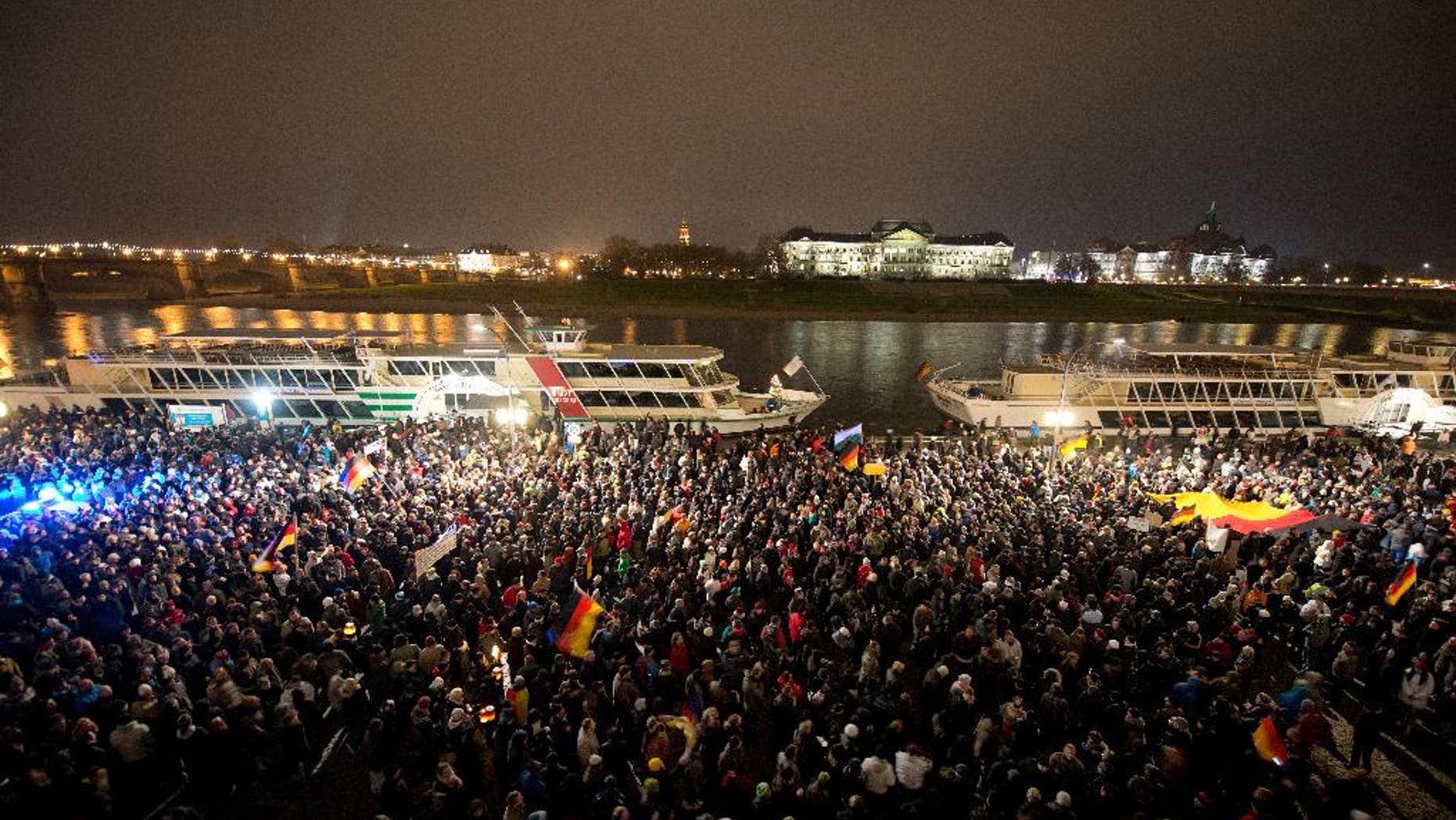 FILE - In this Dec. 1, 2014 file picture participants of a right-wing group's march called 'Patriotic Europeans against the Islamization of the West' (PEGIDA,) gather in Dresden, Germany. The eastern German city of Dresden is bracing itself for one of the biggest far-right marches the country has seen in years. City officials say Friday Dec. 5, 2014 organizers have told them 8,000 will take part in the protest Monday, billed as a march against Islamic extremism. The protest is organized by a group called PEGIDA, a German acronym for 'Patriotic Europeans against the Islamization of the West.' Over the past two months it has organized seven protests in Dresden, growing from 200 at the first march to 7,500 people last Monday. (AP Photo/dpa,Arno Burgi,File)