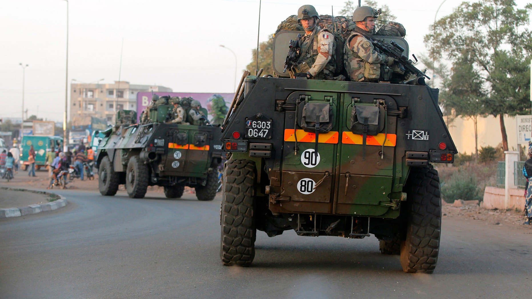 FILE - In this Jan. 15, 2013 file photo, French troops in two armored personnel carriers drive through Mali's capital Bamako on the road to Mopti. The Obama administration has declared it cannot accept new terrorist sanctuaries in Mali or anywhere else and has promised to support French and African efforts to restore security. Yet after almost a year of disorder in the West African nation, Washington is still keeping the conflict at arm’s length. (AP Photo/Jerome Delay, File)