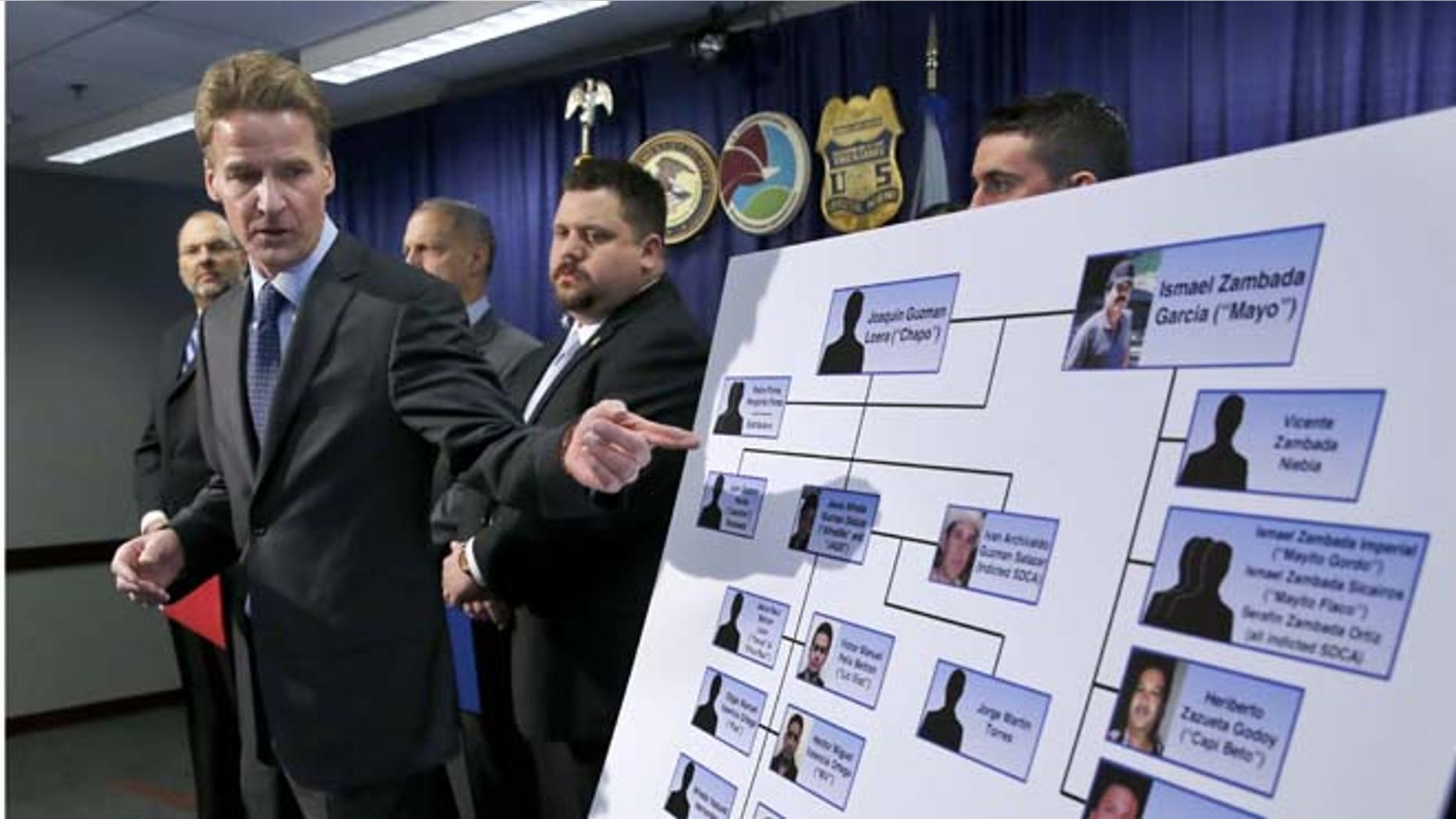 U.S. Attorney Zachary T. Fardon makes reference to a chart of know Mexico-based Sinaloa Cartel members, during a news conference after twin brothers Pedro and Margarito Flores were sentenced to 14 years for their drug related activities in the cartel, Tuesday, Jan. 27, 2015, in Chicago. Fardon characterized the Flores brothers cooperation in bringing down the cartel as extraordinary. He says their reduced sentences should illustrate to criminals that, "You can right some of what you did wrong, by helping the government." (AP Photo/Charles Rex Arbogast)