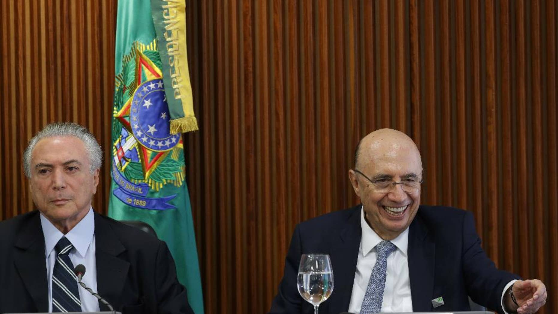 Brazil's acting President Michel Temer, left, presides over his first cabinet meeting, at the Planalto presidential palace in Brasilia, Brazil, Friday, May 13, 2016. Newly named Finance Minister Henrique Meirelles is pictured at right. (AP Photo/Eraldo Peres)