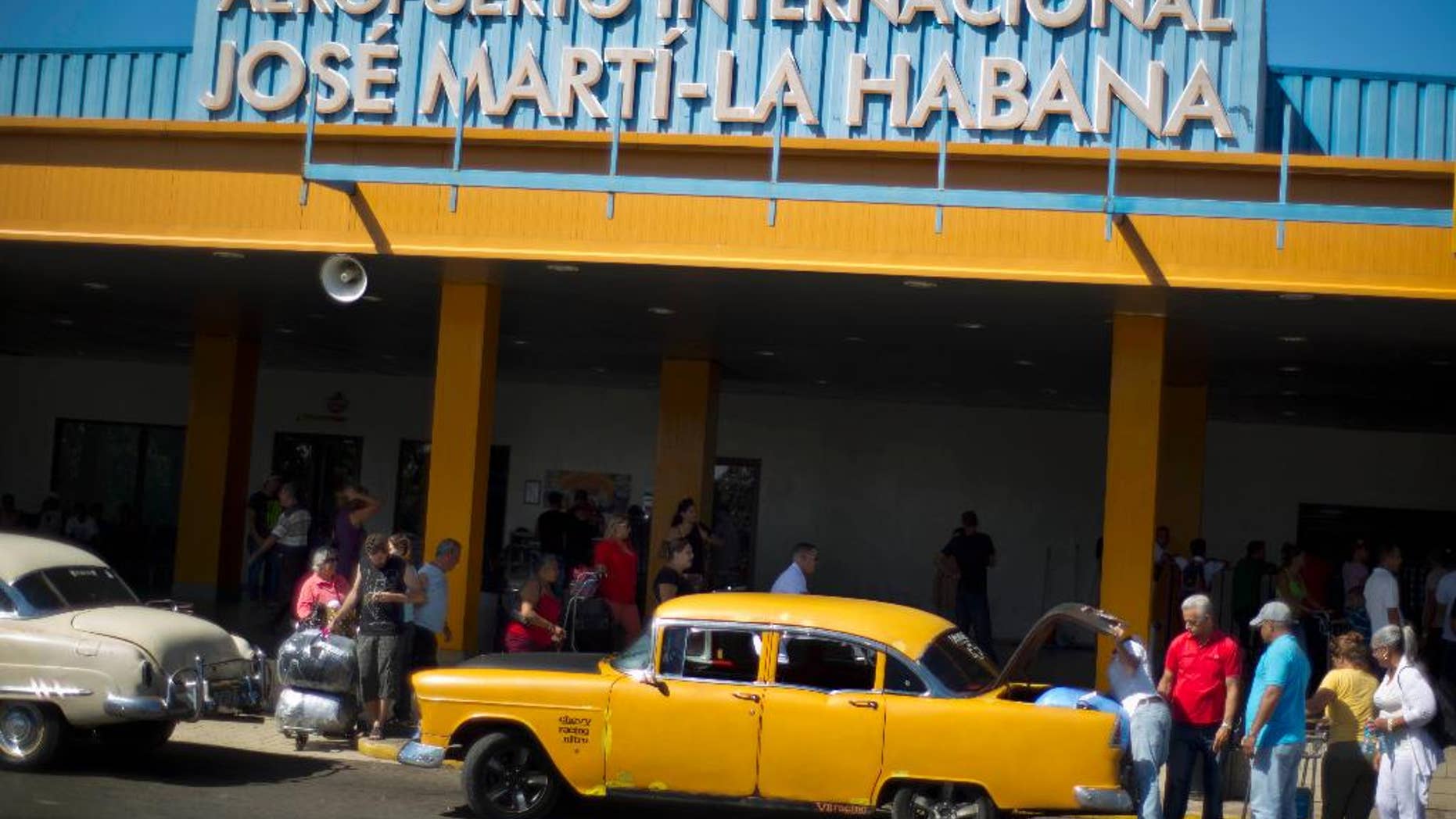 FILE - In this Sept. 1, 2014 file photo, people put their luggage in a private taxi as they arrive from the U.S. to the Jose Marti International Airport in Havana, Cuba. The rise in Cuba's tourism has strained the country's infrastructure, filling hotels to capacity and creating long waits at airport. The government announced Wednesday, Aug. 3, 2016, that Aeroports de Paris, the French government-controlled firm that runs Charles de Gaulle, Orly and other Paris airports, would receive a concession to operate Jose Marti, which would be renovated by the French firm Bouygues. (AP Photo/Ramon Espinosa, File)