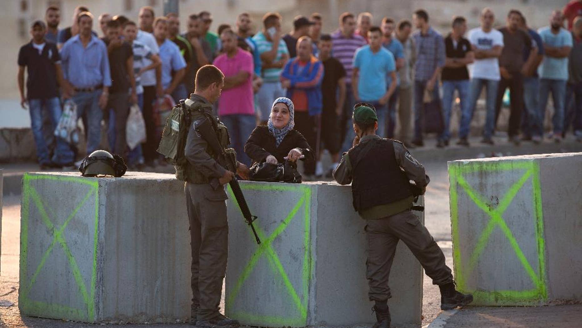 Israeli border police check Palestinian's IDs at a checkpoint as they exit the Arab neighborhood of Issawiyeh in Jerusalem, Sunday, Oct. 18, 2015. Palestinian assailants carried out a series of five stabbing attacks in Jerusalem and the West Bank on Saturday, as a month-long outburst of violence showed no signs of abating. The unrest came despite new security measures that have placed troops and checkpoints around Palestinian neighborhoods in east Jerusalem. (AP Photo/Oded Balilty)