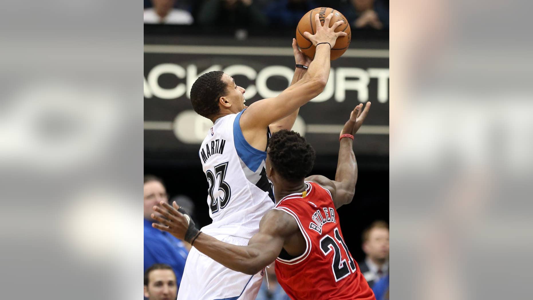 Minnesota Timberwolves' Kevin Martin , left, attempts a shot in front of Chicago Bulls' Jimmy Butler in the second half of an NBA basketball game, Saturday, Nov. 1, 2014, in Minneapolis. The Bulls won 106-105. MArtin led the Timberwolves with 33 points and Butler led the Bulls with 24. (AP Photo/Jim Mone)