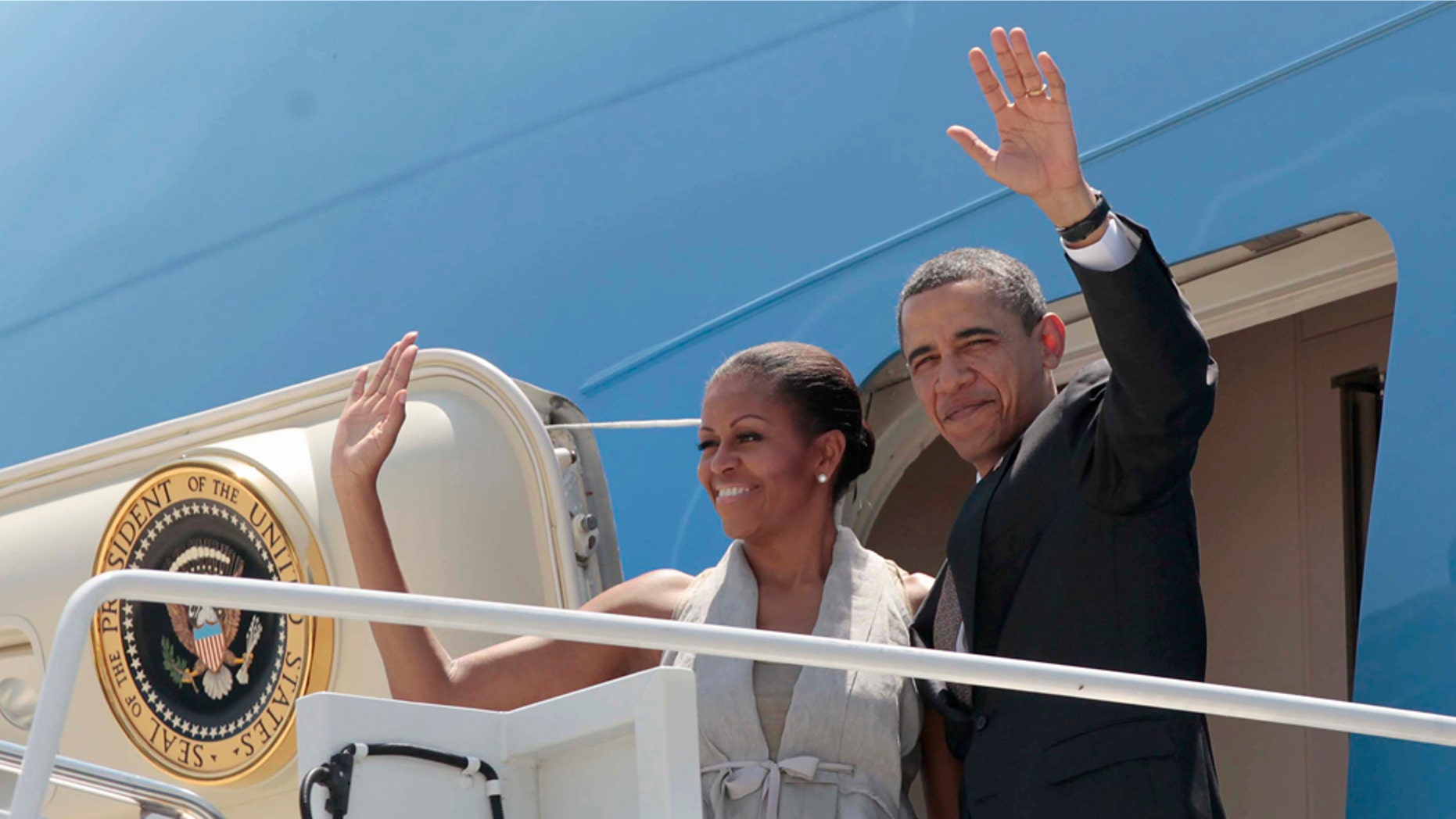 President Barack Obama and first lady Michelle Obama wave prior to boarding Air Force prior to departing San Salvador, El Salvador, Wednesday, March 23, 2011. (AP Photo/Pablo Martinez Monsivais)