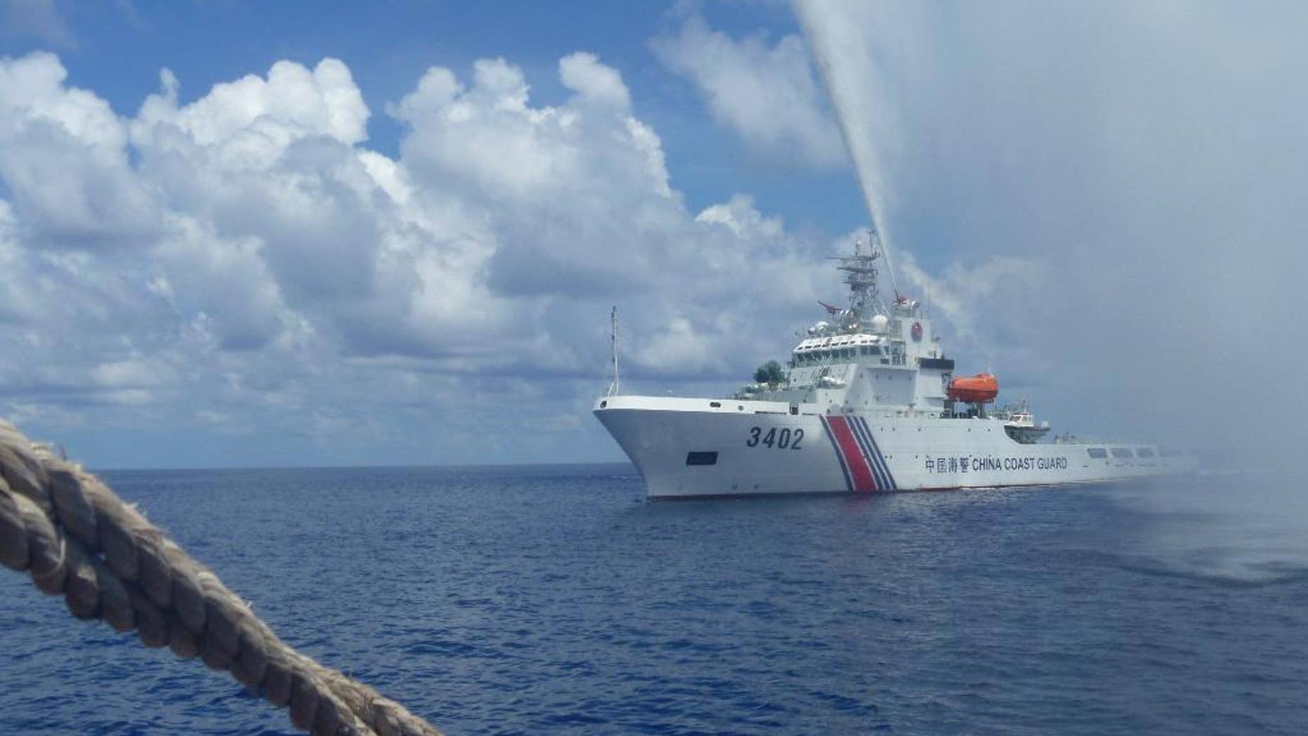 FILE - In this Sept. 23, 2015, file photo, Chinese Coast Guard members approach Filipino fishermen as they confront each other off Scarborough Shoal in the South China Sea, also called the West Philippine Sea. The Philippines' new president said Tuesday July 5, 2016, that Manila is ready to talk to China, not go to war, if an arbitration tribunal rules in its favor in a case it brought against Beijing's claims in the South China Sea. (AP Photo/Renato Etac, File)
