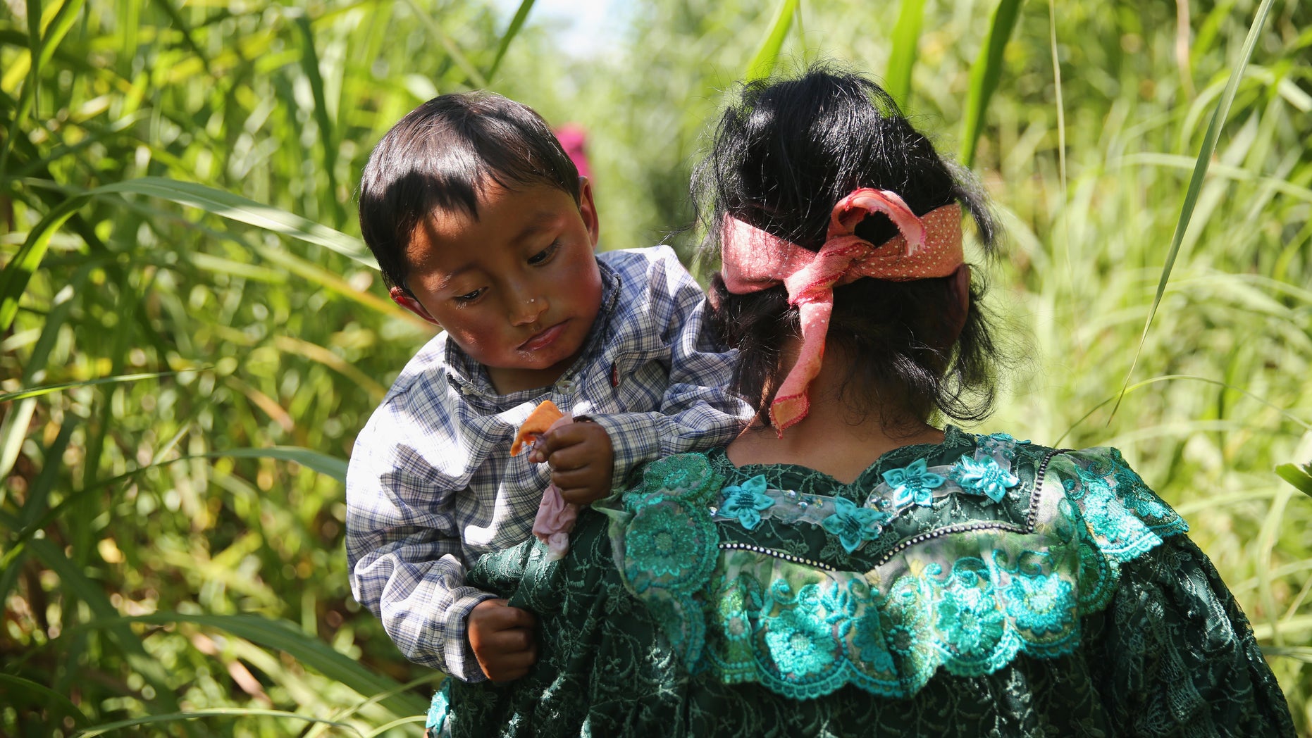 TALISMAN, MEXICO - AUGUST 01: An Indigenous family walks from Guatemala into Mexico after illegally crossing the border at the Suchiate River on August 1, 2013 in Talisman, Mexico. They passed directly under a bridge with a Mexican immigration checkpoint. Thousands of Central Americans pass illegally into Mexico daily, many on the first leg of their long and perilous journey north towards the United States. (Photo by John Moore/Getty Images)