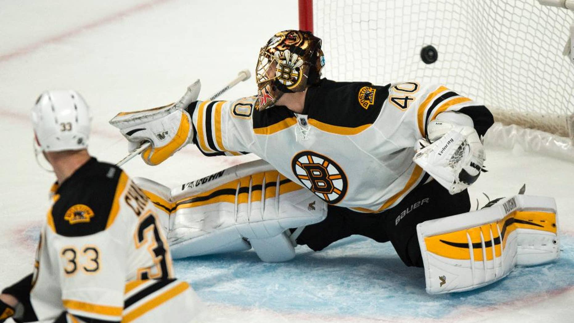 The puck flies over Boston Bruins goalie Tuukka Rask on a goal by Montreal Canadiens' P.A. Parenteau during second-period NHL hockey game action Thursday, Oct. 16, 2014, in Montreal. (AP Photo/The Canadian Press, Paul Chiasson)