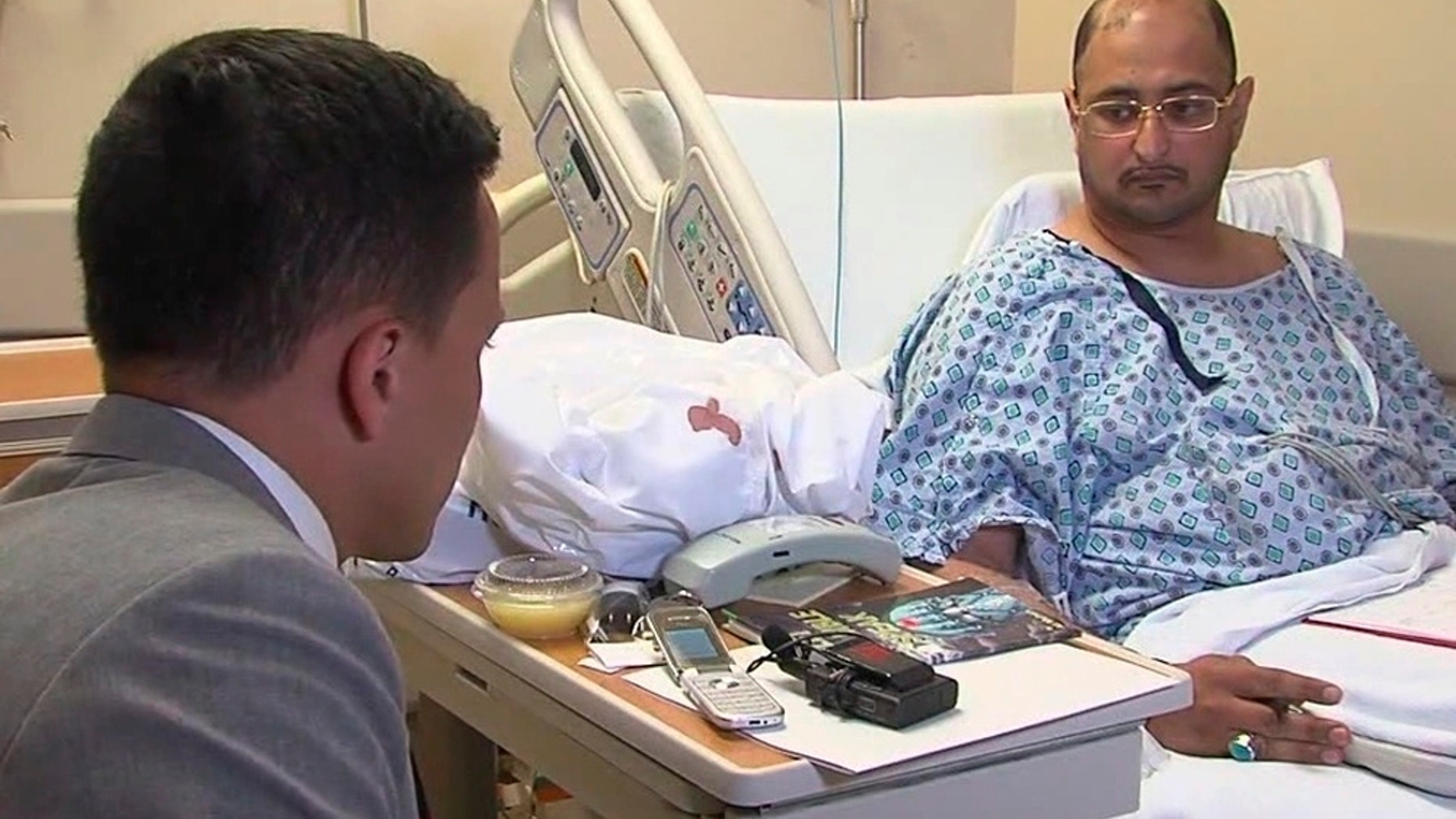 FILE - In this June 29, 2016 file still image from video, Ahmed al-Menhali, right, is interviewed by WEWS at St. John Medical Center after he collapsed following an encounter with police in Avon, Ohio. A prosecutor continues to investigate the detention by police at gunpoint of the businessman from the United Arab Emirates at a northeast Ohio hotel, after a hotel clerk raised suspicions that he could have links to terrorism. (WEWS via AP, File)