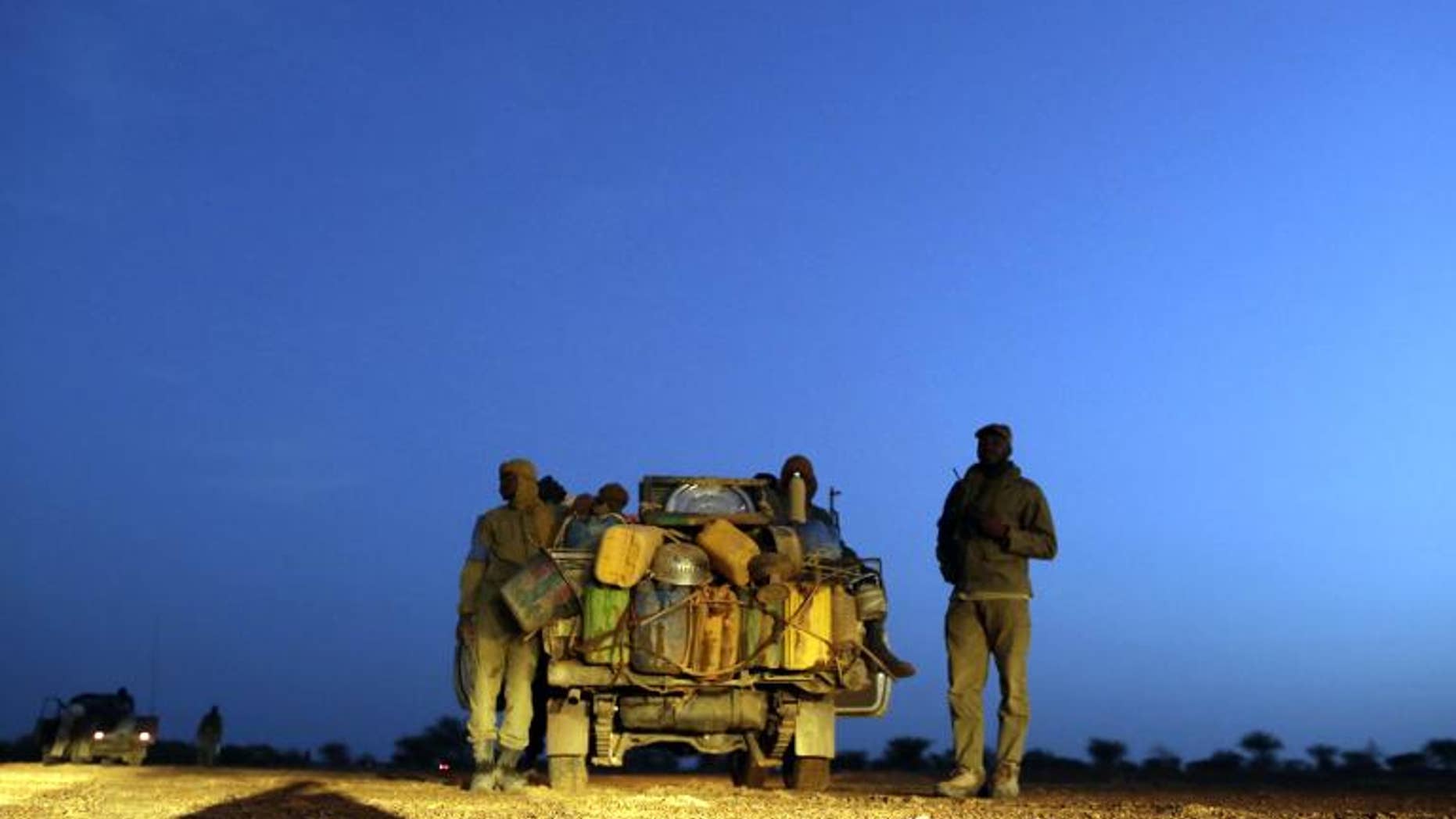 Malian soldiers patrol on a road between Kidal and Gao on July 29, 2013 in northern Mali.