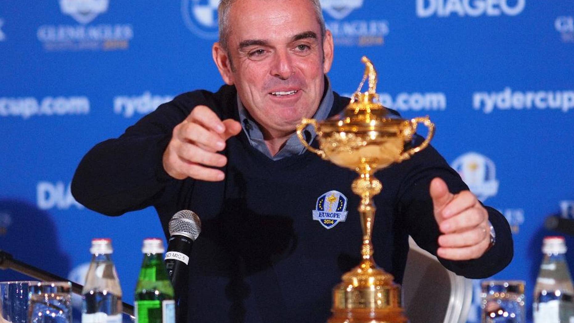 FILE - This is a Tuesday, Jan. 15, 2013 file photo of Paul McGinley of Ireland reaches for the trophy after being named as team Captain for the 2014 European Ryder Cup Team following a meeting of the Tournament Committee of the European Tour in Abu Dhabi, United Arab Emirates. McGinley's will lead the European team against the U.S. at Gleneagles in Scotland for the 2014 Ryder Cup, starting Friday Sept 26, 2014. The European team has not lost at home in 20 years. (AP Photp/Manuel Salazar, File)