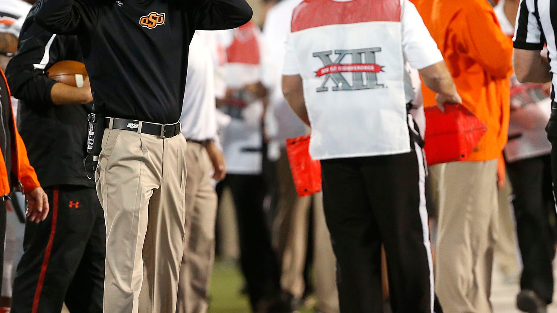 Oklahoma State coach Mike Gundy watches as his team competes against Texas Tech during their NCAA college football game in Lubbock, Texas, Saturday, Nov. 2, 2013. (AP Photo/Lubbock Avalanche-Journal,Stephen Spillman)
