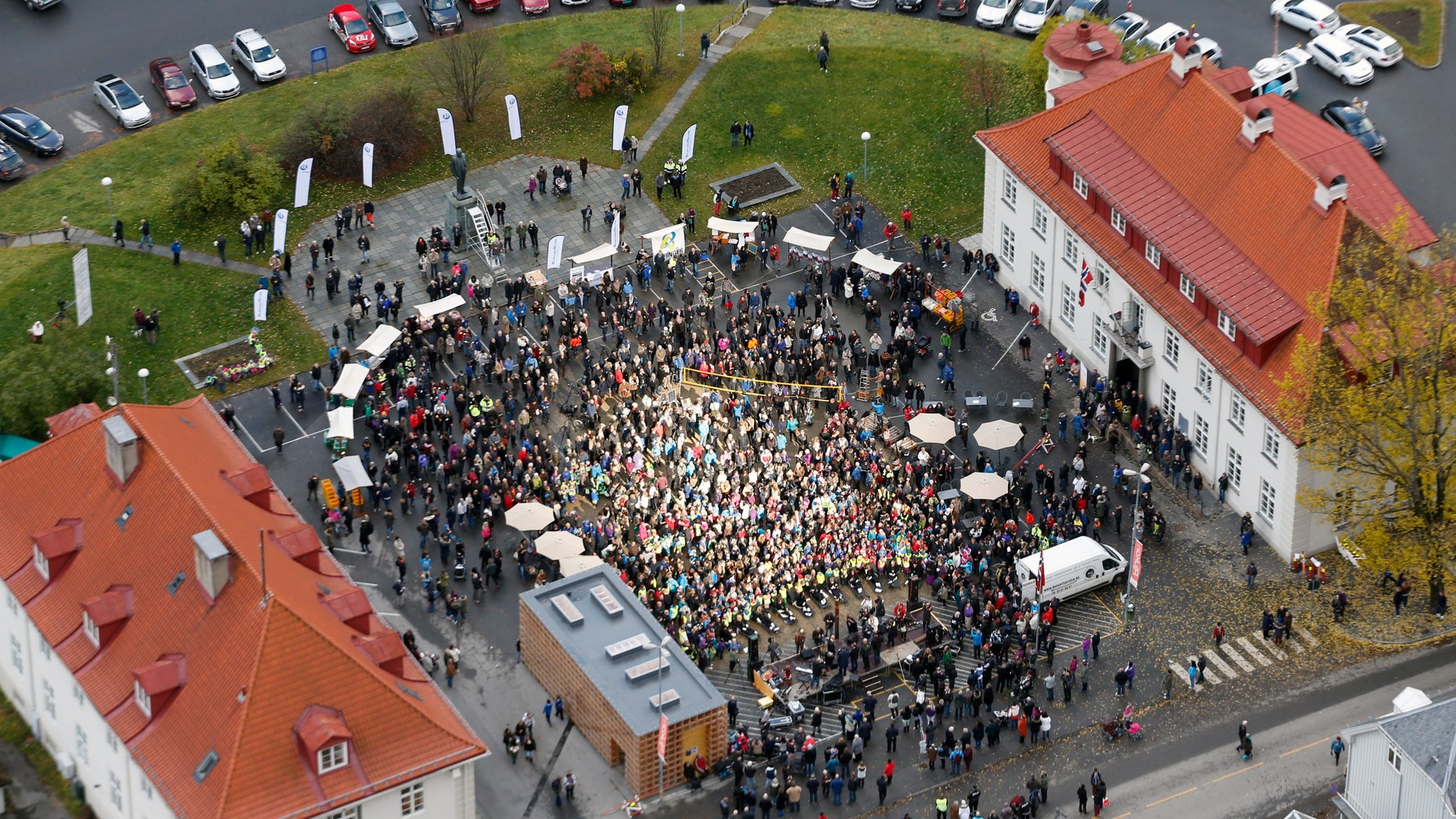 A crowd forms, those in the centre bathing in sunlight, for the official opening of giant sun mirrors in the town of Rjukan, Norway, Wednesday, Oct. 30, 2013. Residents of the small Norwegian town of Rjukan have finally seen the light. Tucked in between steep mountains, the town is normally shrouded in shadow for almost six months a year. But on Wednesday faint rays from the winter sun for the first time reached the market square thanks to three 183-square-foot (17-square-meter) mirrors placed on a mountain. (AP Photo/NTB Scanpix, Terje Bendiksby) NORWAY OUT