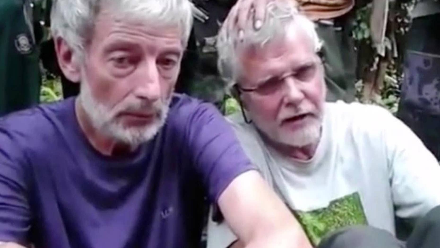 This image made from undated militant video, shows Canadians John Ridsdel, right, and Robert Hall. Canada's Prime Minister Justin Trudeau confirmed that the decapitated head of a Caucasian male recovered Monday, April 25, 2016, in the southern Philippines belongs to Ridsdel, who was taken hostage by Abu Sayyaf militants in September 2015. (Militant Video via AP Video) NO SALES, MANDATORY CREDIT