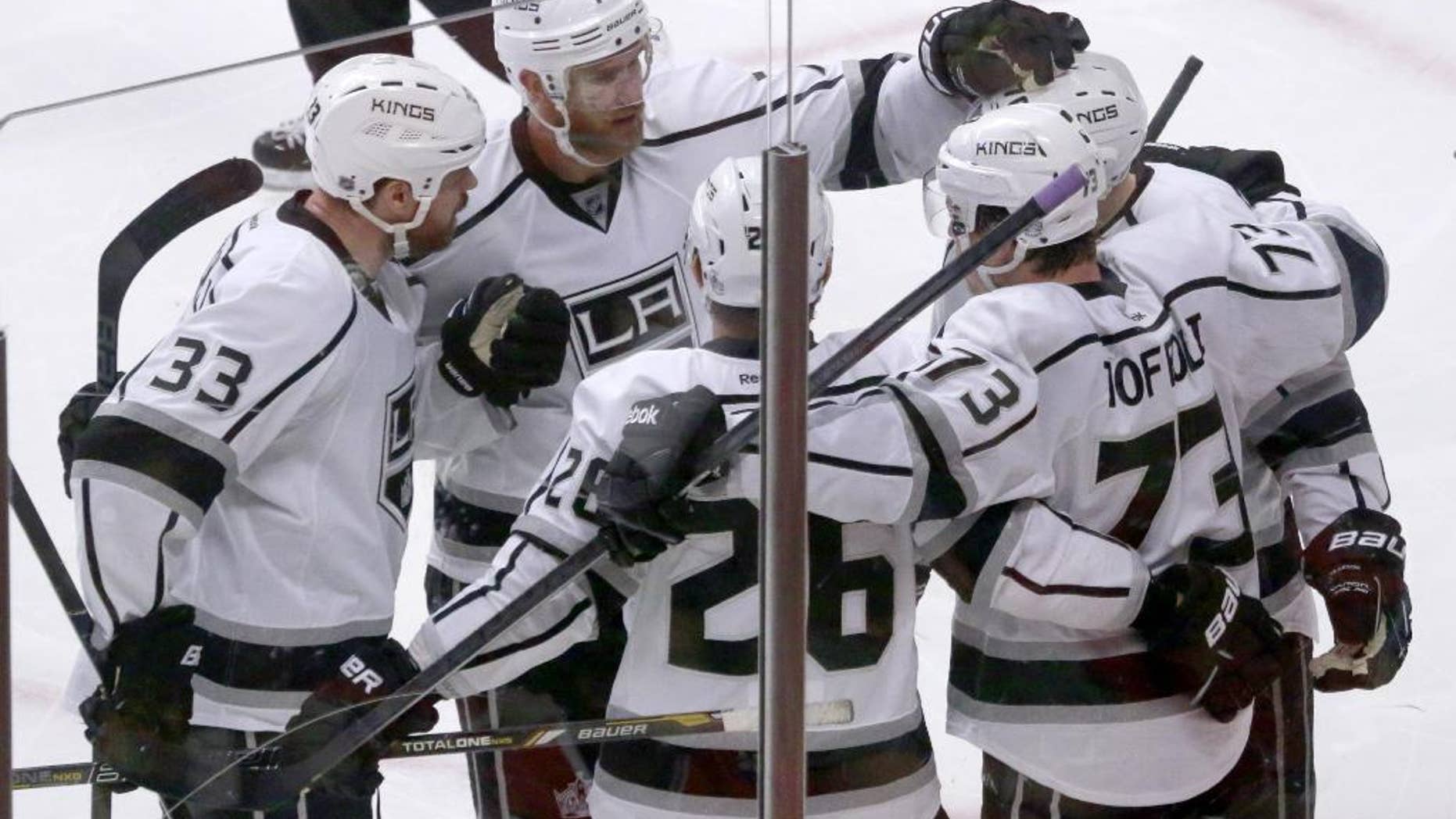 The Los Angeles Kings gather around center Tyler Toffoli as they celebrate Toffoli's goal during the third period of Game 2 of the Western Conference finals in the NHL hockey Stanley Cup playoffs against the Chicago Blackhawks on Wednesday, May 21, 2014, in Chicago. From left are Willie Mitchell (33), Jeff Carter (77), Slava Voynov (26), Toffoli, and Tanner Pearson. (AP Photo/Charles Rex Arbogast)