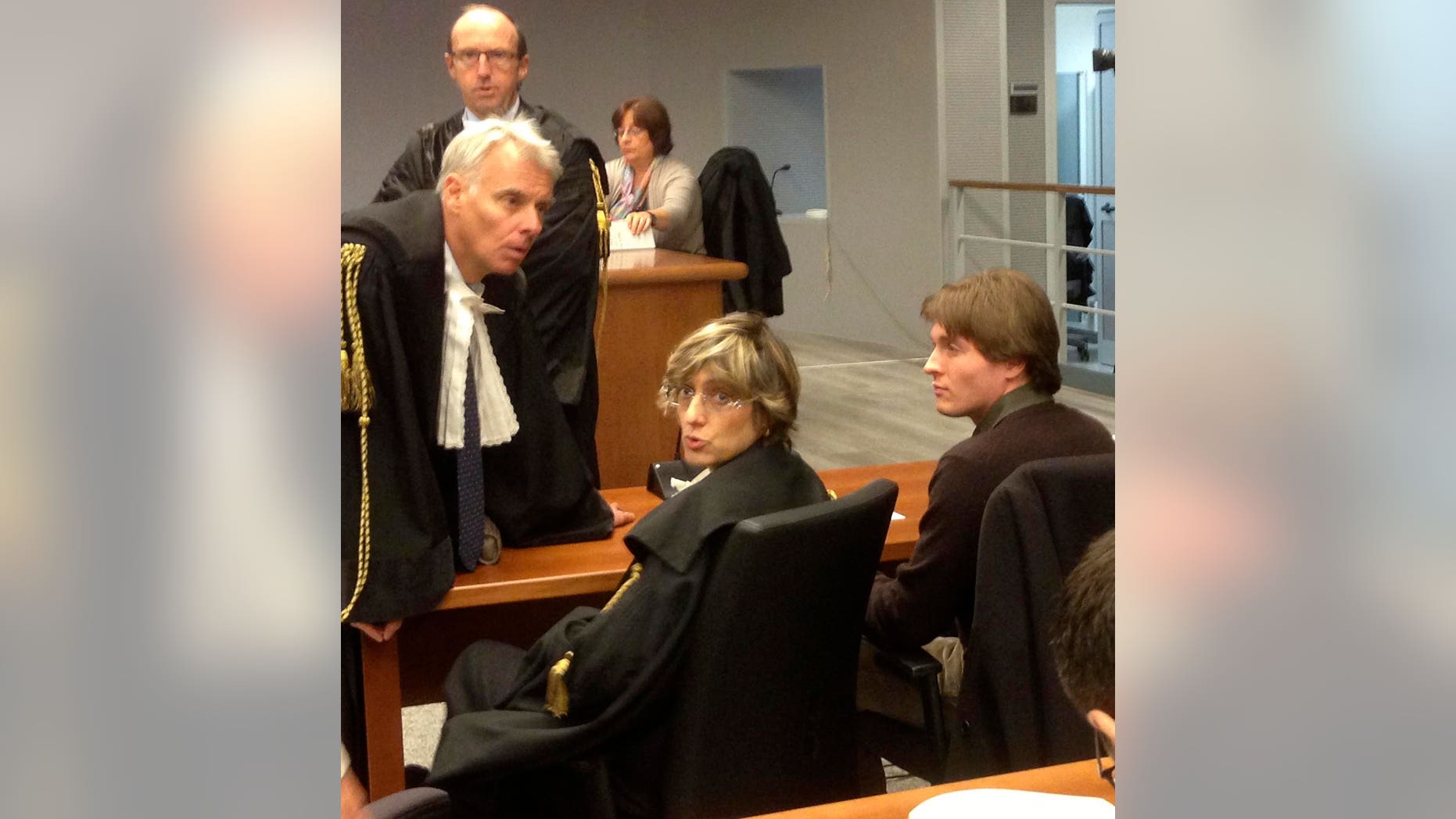 FILE - In this Wednesday, Nov. 6, 2013 file photo taken with a mobile phone, former American exchange student Amanda Knox's Italian ex-boyfriend Raffaele Sollecito, right, sits with his lawyer Giulia Bongiorno, center, as Knox's lawyer Carlo Dalla Vedova speaks to them ahead of a hearing in Sollecito and Knox's trial at an appeals court in Florence, Italy. Knox spent four years in jail in Italy, from her arrest to her conviction in her first murder trial through her successful appeal. She’s now facing a second appeals trial, along with Sollecito. (AP Photo/Patricia Thomas, File)