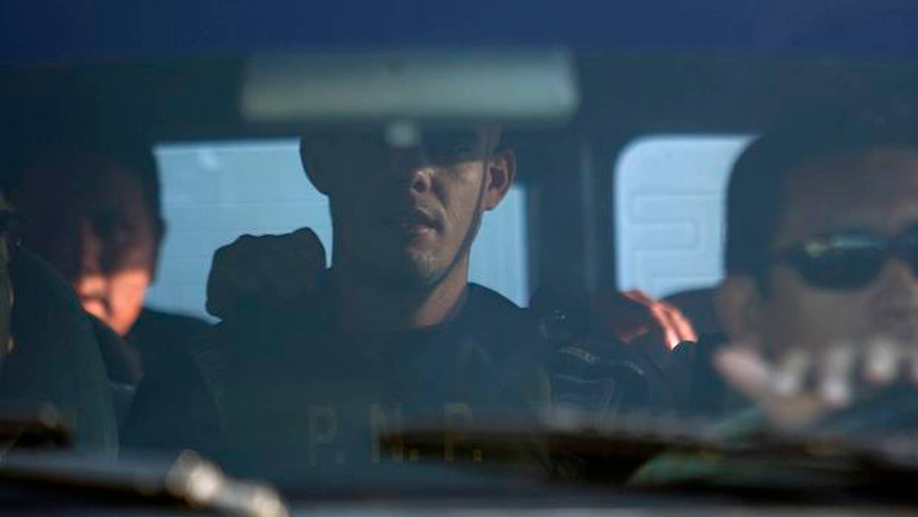 Dutch citizen Joran Van der Sloot , center, is carried inside a Peruvian police car to "La Concordia" Peruvian police station, near the border between Peru and Chile in Tacna, Peru, Friday, June 4, 2010. Peruvian police were seeking Van der Sloot in connection with the last May 30 killing of 21-year-old Stephany Flores at a Lima hotel. Van der Sloot was previously arrested in the 2005 disappearance of U.S. teen Natalee Holloway, but later released by Dutch authorities. (AP Photo/Karel Navarro)
