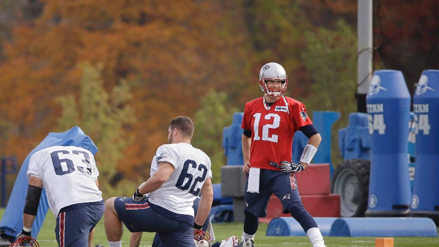 New England Patriots quarterback Tom Brady (12) stretches with offensive linemen Ryan Wendell (62) and Dan Connolly (63) before practice begins at the NFL football team's facility Wednesday, Oct. 29, 2014 in Foxborough, Mass. The Patriots (6-2) will play the Denver Broncos (6-1) Sunday in Foxborough. (AP Photo/Stephan Savoia)