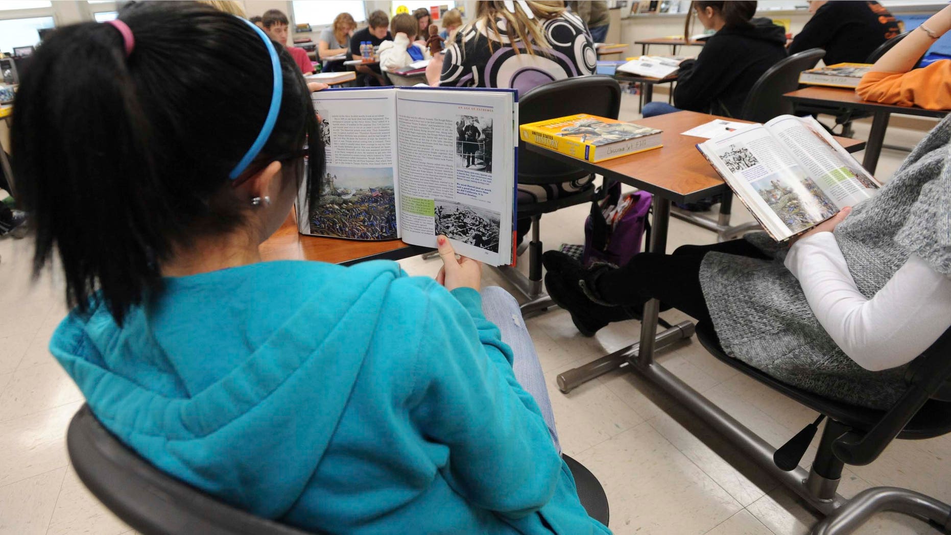 ** FOR USE MONDAY, Dec. 13 AND THEREAFTER** In this photo taken on Dec. 3, 2010, sophomore Ariel Russell follows along in her book as another student reads out loud in the John Jackson's U.S. history class at the Franklin High School in Franklin, Ind. School officials hope to give even more students a chance to earn college credits by making more dual-credit courses available. The goal is to get students who are planning to attend college a head start, as well as to give students the confidence that they can succeed in college level courses. (AP Photo/Daily Journal, Scott Roberson)