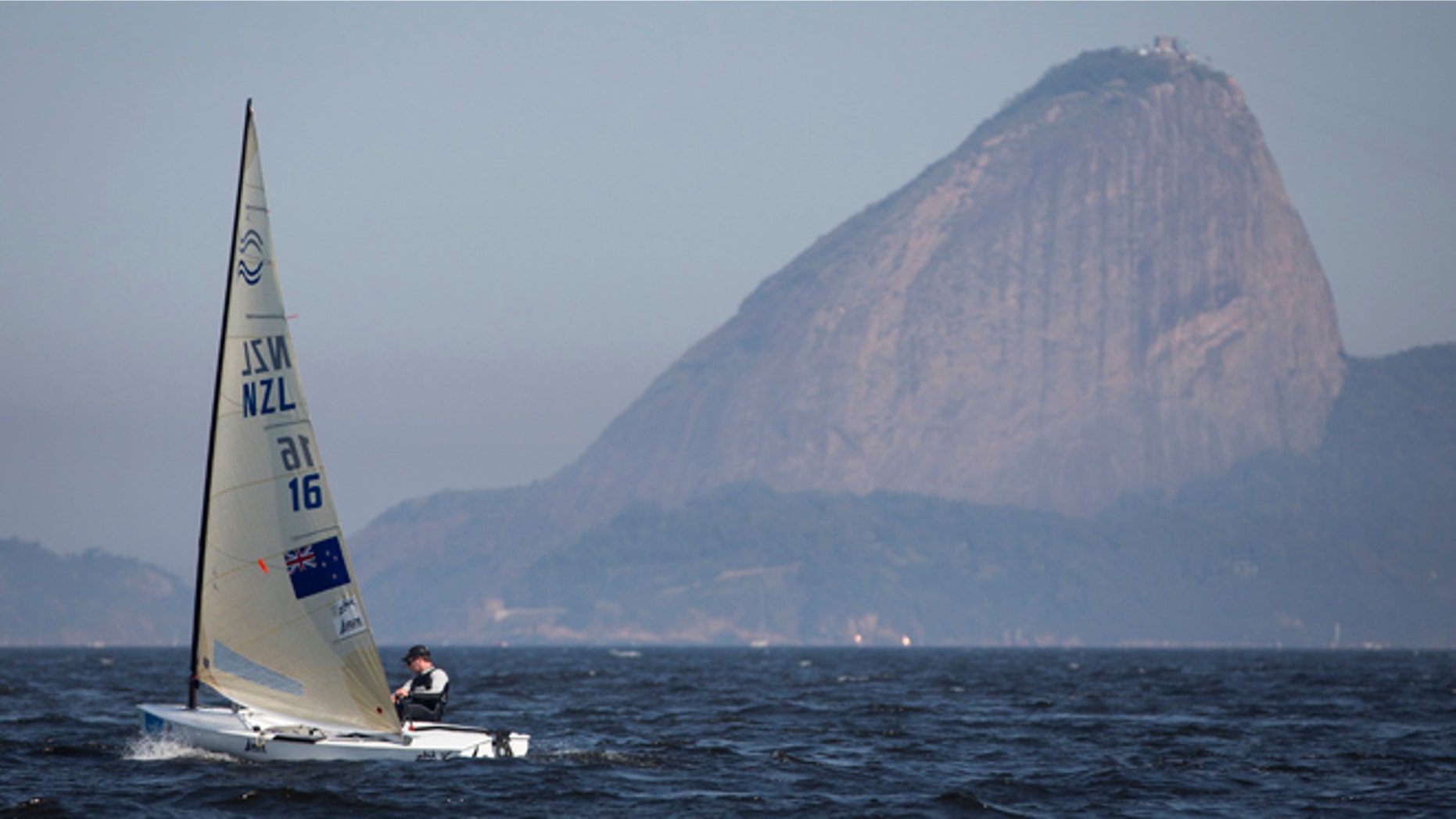 New Zealand's Finn class Andrew Murdoch competes during the first test event for the Rio 2016 Olympic Games at the Guanabara Bay in Rio de Janeiro, Sunday, Aug. 3, 2014. Sugar Loaf Mountain is seen on the background. American sailing officials have hired medical experts to test the water in Guanabara, which has suffered from decades of untreated human waste being poured into the bay. (AP Photo/Felipe Dana)