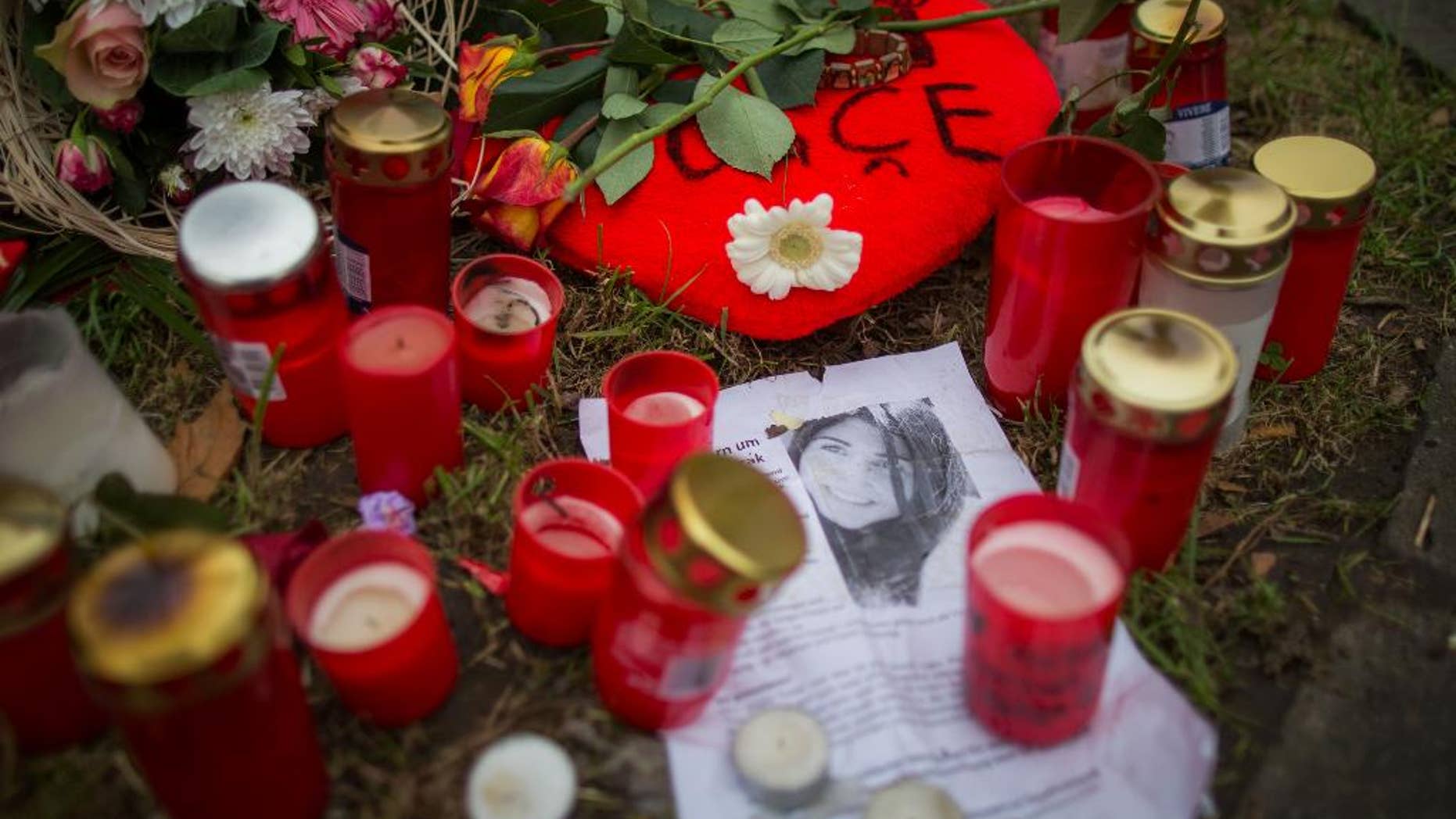 Candles and flowers are placed on the parking lot where Tugce was fatally injured two weeks ago in Offenbach, Germany, Monday Dec.1, 2014. Germany's president is considering awarding a posthumous medal to the young woman killed after defending two teenage girls from male harassment. German news agency dpa reported Sunday that President Joachim Gauck was mulling the honor amid an outpouring of public outrage over the killing. Student teacher Tugce Albayrak died Friday, her 23rd birthday, after her family gave doctors permission to switch off her life support. (AP Photo/dpa,Frank Rumpenhorst)