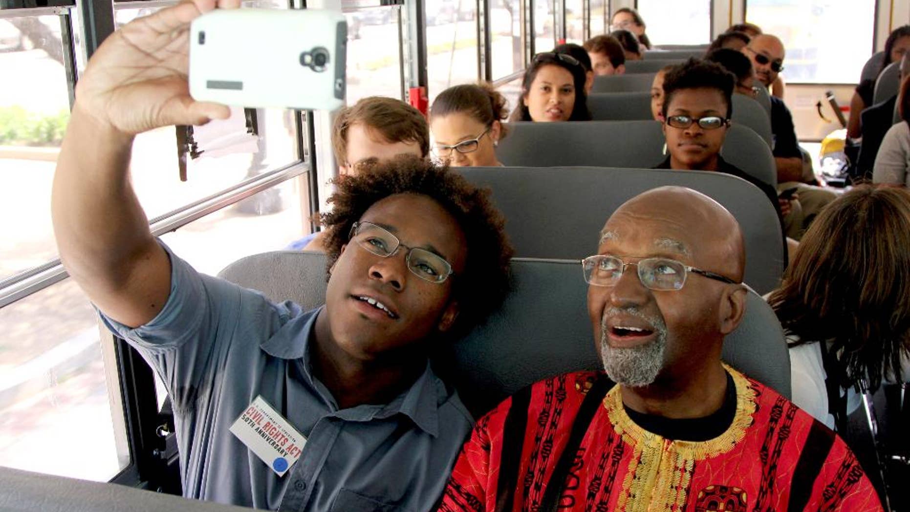 Freedom Rider John Moody and Dennis Johnson, a 23-year-old University of Michigan student from Chicago, take a selfie while riding through Washington, Wednesday, July 2, 2014, commemorating the 50th anniversary of the signing of the Civil Rights Act. The Civil Rights Act of 1964 is considered one of the most celebrated legislative achievements in U.S. history. Signed on July 2, 1964 by President Lyndon B. Johnson, this law made it illegal to discriminate on the basis of race, color, religion, sex, or national origin, and barred unequal application of voter registration requirements. (AP Photo/Connor Radnovich)