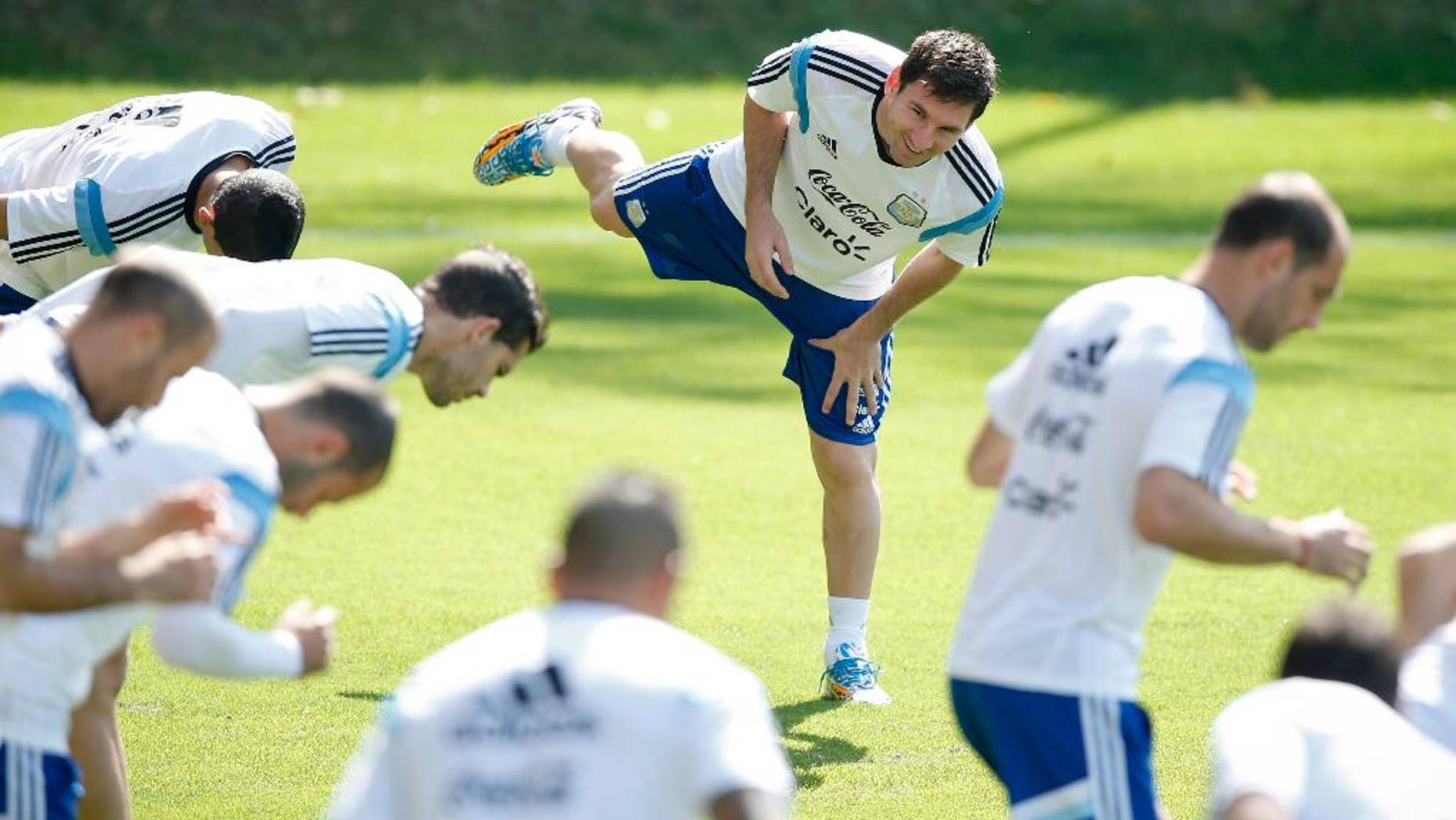 Argentina's Lionel Messi, center, warms up with teammates during a training session in Vespasiano, near Belo Horizonte, Brazil, Friday, June 20, 2014. Argentina plays in group F of the 2014 soccer World Cup. (AP Photo/Victor R. Caivano)