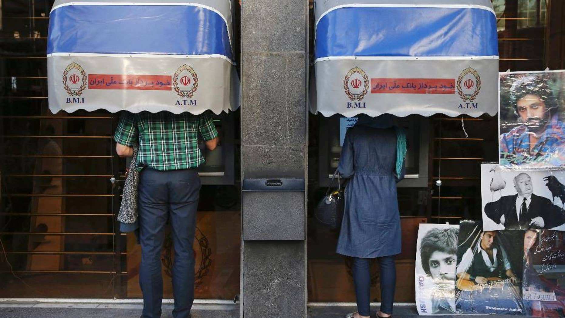 FILE -- In this April 4, 2015 file photo, Iranians use ATM machines of Bank Melli Iran in downtown Tehran, Iran. Iranian media are saying the country's banks will begin issuing credit cards for the first time in decades. Reports by several newspapers, including the daily Donya-e-Eqtesad, Monday, Sept. 26, 2016 said the cards will be for domestic use only and do not involve any sort of partnership with a major international credit card company. So far, Iranian banks have only issued debit and prepaid cards. (AP Photo/Vahid Salemi, File)