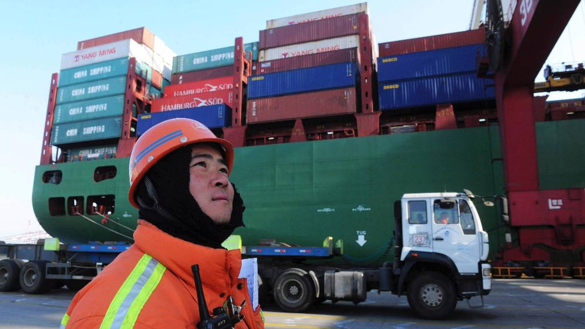 FILE - In this Feb. 15, 2016, file photo, a port worker stands near a container ship at a port in Qingdao in eastern China's Shandong province. Chinese exports have risen for the first time in nine months, in a sign that the outlook may be improving for the world’s No. 2 economy. Customs data posted online Wednesday, April 13, 2016, show that China’s exports rose 11.5 percent in March compared with a year earlier, to $160.8 billion, after slumping by 25 percent in February. (Chinatopix via AP, File) CHINA OUT