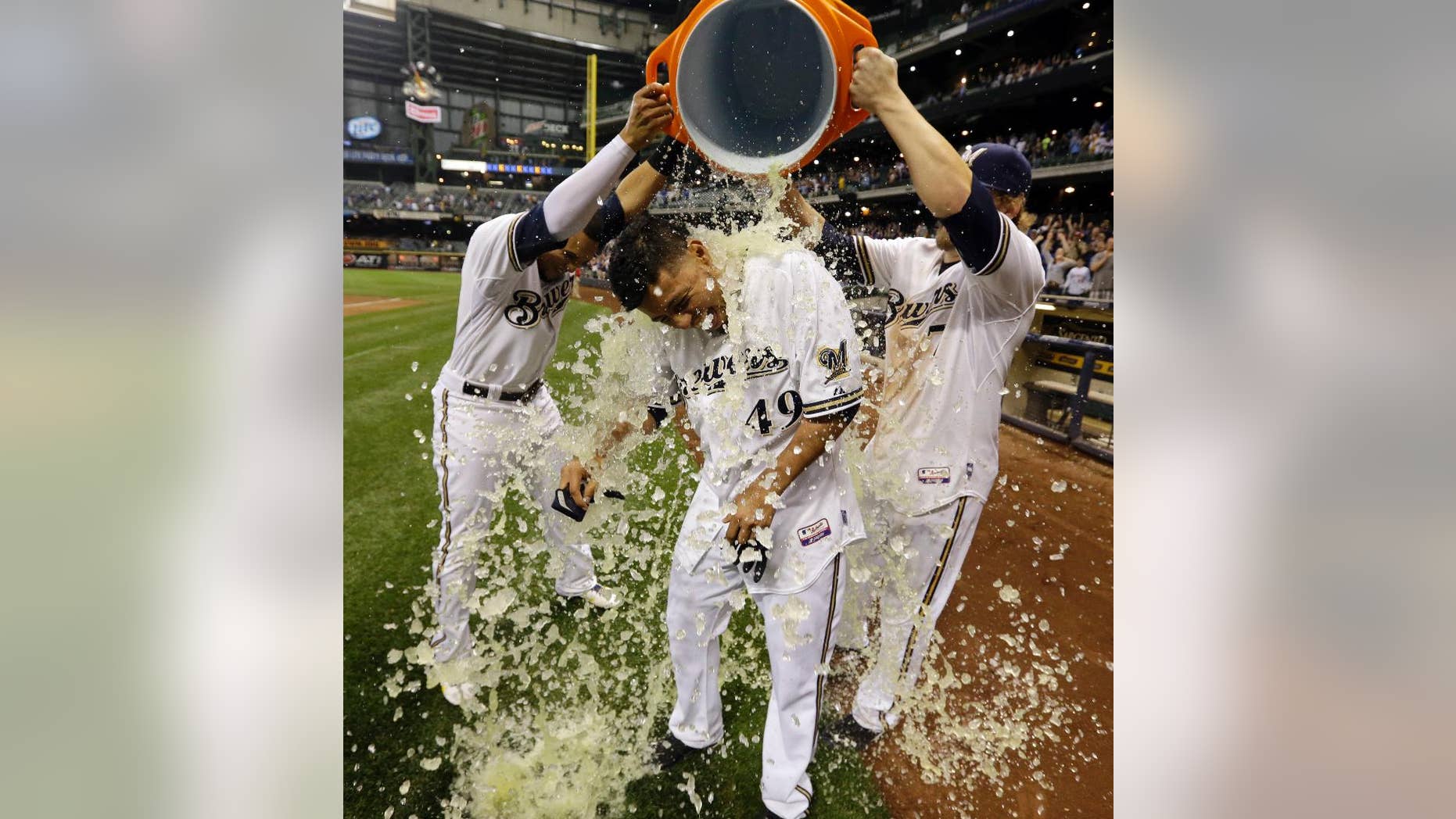 Milwaukee Brewers' Yovani Gallardo is dunked by teammates Mark Reynolds (7) and Carlos Gomez after hitting a game-winning double during the 10th inning of a baseball game against the Baltimore Orioles Tuesday, May 27, 2014, in Milwaukee. The Brewers won 7-6. (AP Photo/Morry Gash)