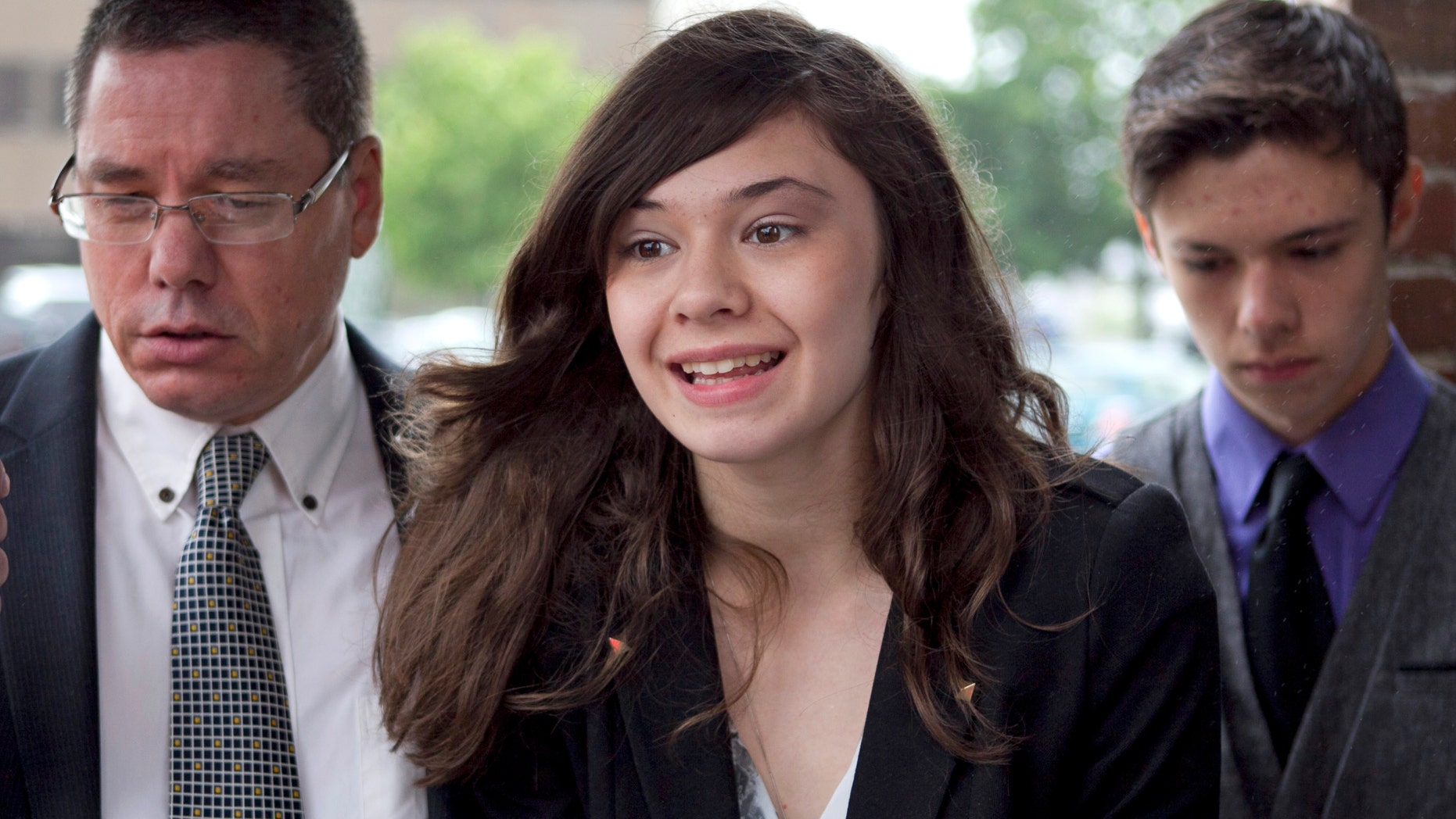 FILE - In this June 12, 2013 file photo, transgender student Nicole Maines, center, with her father Wayne Maines, left, and brother Jonas, speaks to reporters outside the Penobscot Judicial Center in Bangor, Maine. The Maine Supreme Judicial Court ruled Thursday, Jan. 30, 2014, that Nicole Maines should have been allowed to use the bathroom of her choice in 2009 after school officials required her to use a staff bathroom instead of the girls' restroom. The high court concluded that the Orono school district's actions violated the Maine Human Rights Act, a state law that bans discrimination based on sexual orientation. (AP Photo/Robert F. Bukaty, File)