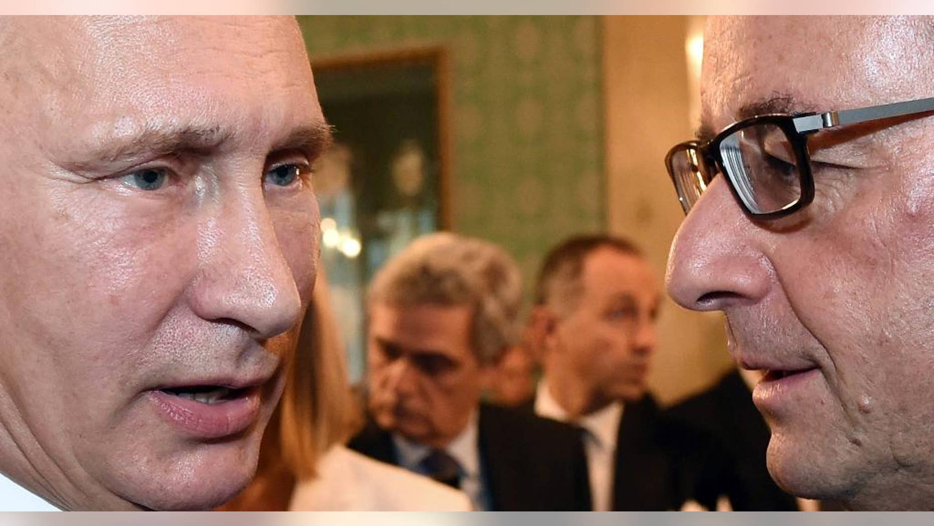 FILE - This is a Friday, Oct. 17, 2014 file photo of Russian President Vladimir Putin and French President Francois Hollande, right, during a meeting on the sidelines of the ASEM summit of European and Asian leaders in Milan, northern Italy. EU sanctions against Russia over the crisis in Ukraine are cutting both ways and pinching some big European companies. But economic relief isn't likely any time soon, diplomats and analysts say: EU rules make the sanctions tough to overturn. France, Germany, Russia and Ukraine are trying to set up talks in Astana, Kazakhstan, toward easing the tensions behind sanctions that have hit Russia's economy, sent the ruble sinking and affected corporate Europe _ including banks, oil companies, machinery makers and food giants. (AP Photo/Daniel Dal Zennaro, Pool, File)