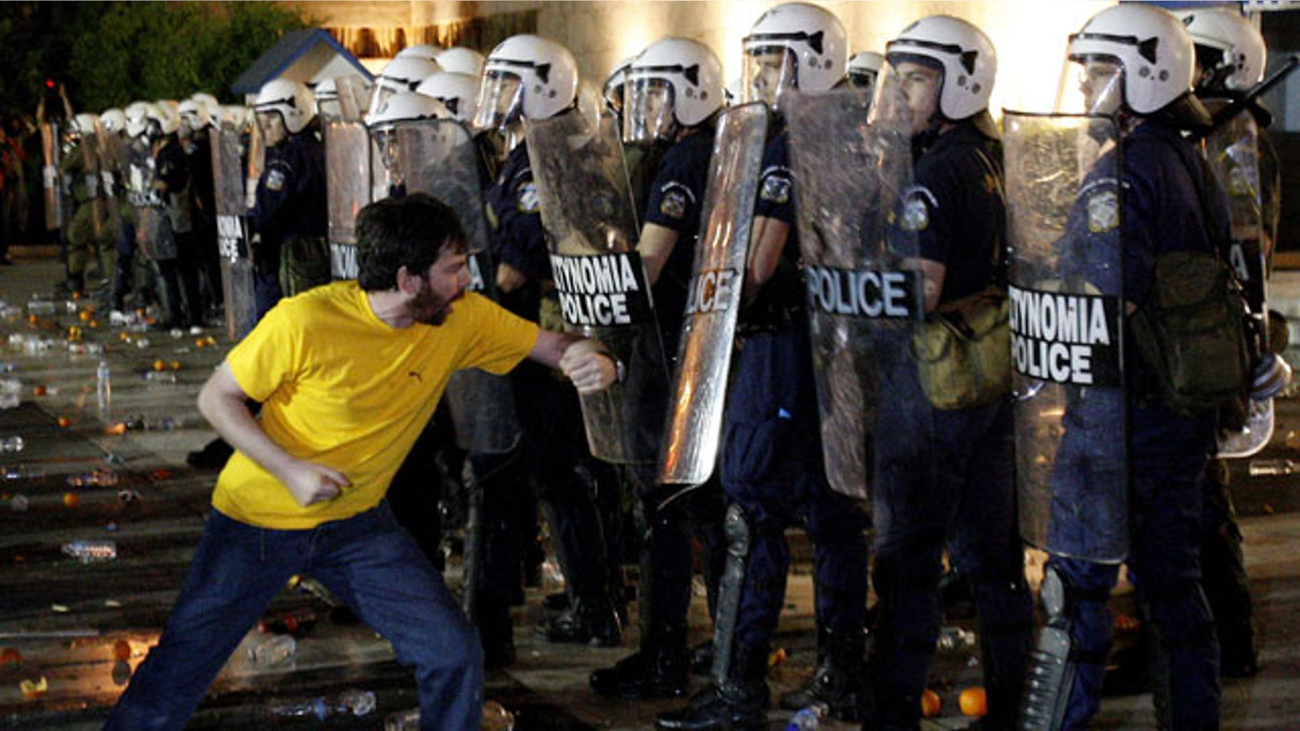 May 6: A protestor gestures to the riot police officers as they stand outside the Greek parliament during an anti government rally in Athens.
