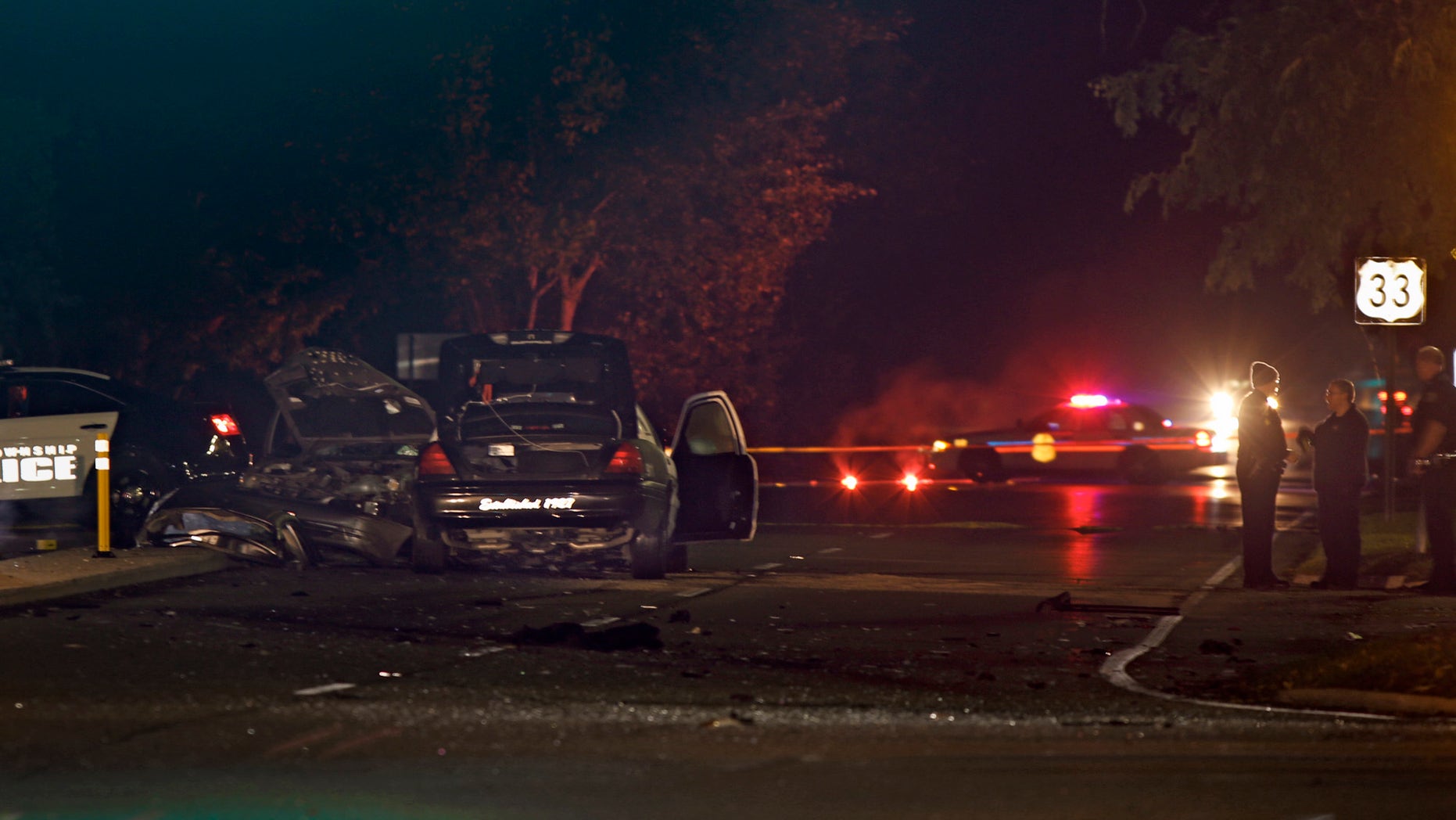 Police investigate the scene of a collision between a car and a police cruiser in Upper Arlington, Ohio early Friday, Oct. 18, 2013. An officer from the Columbus suburb of Upper Arlington was responding to a robbery report when the overnight crash occurred at an intersection, said Jason Pappas, head of the local police union. According to Pappas, six people in the other vehicle died, including a small child. The officer was being treated for a serious head injury at a hospital but was in stable condition. (AP Photo/Columbus Dispatch,Tom Dodge) MANDATORY CREDIT