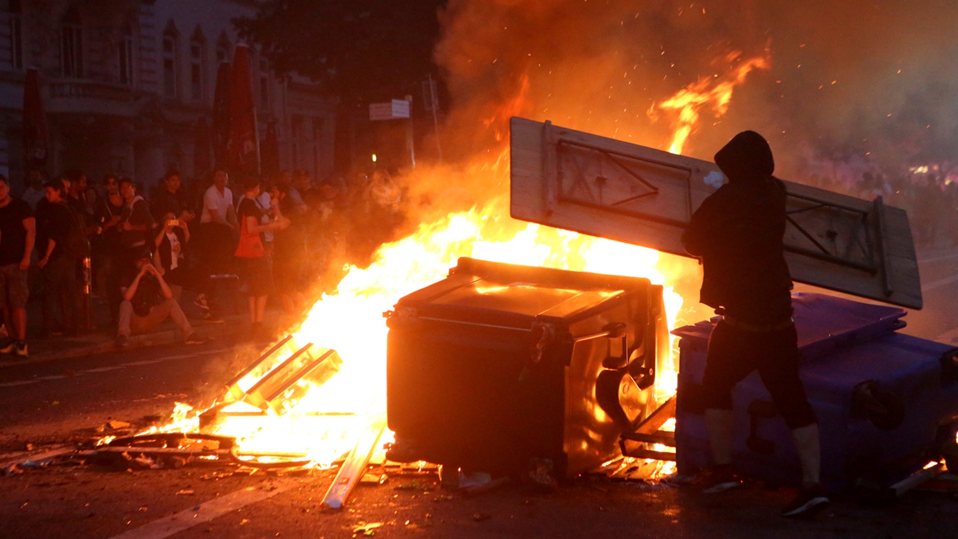 July 7: Protestors are silhouetted against a fire during demonstrations against the G-20 summit Hamburg