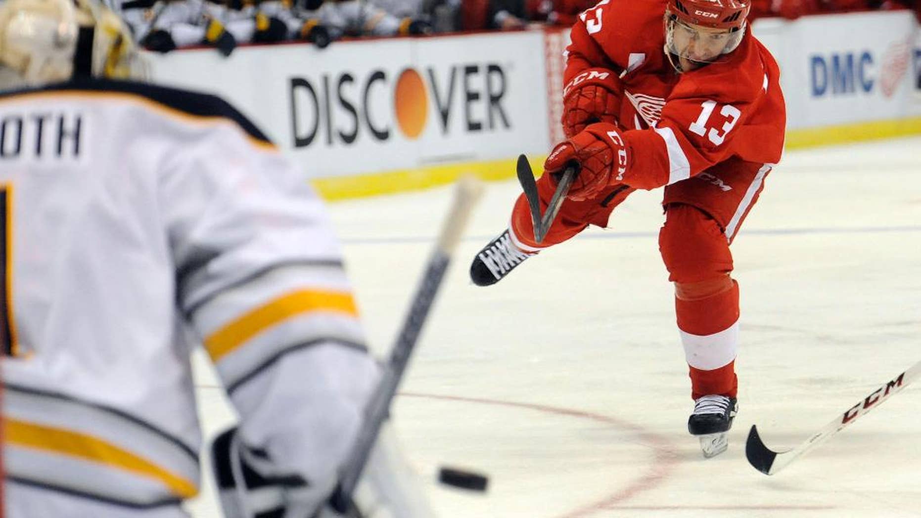 Detroit Red Wings center Pavel Datsyuk (13) of Russia, right, shoots the puck at Buffalo Sabres goalie Jhonas Enroth (1) of Sweden in the first period of an NHL hockey game at Joe Louis Arena in Detroit, Sunday, Jan. 18, 2015. (AP Photo/Jose Juarez)