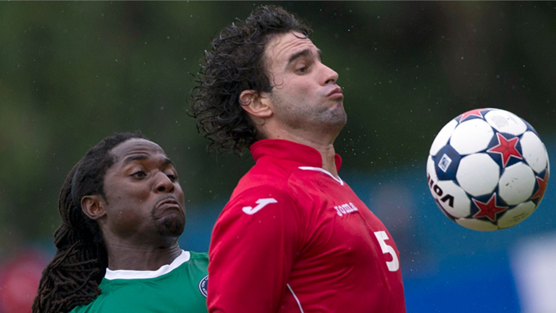 New York Cosmos' Lucky Mkosana, left, fights for the ball against Cuba's Jorge Luis Clavelo during their friendly soccer match at the Pedro Marrero stadium in Havana, Cuba, Tuesday, June 2, 2015. Cosmos won the game 4-1. (AP Photo/Ramon Espinosa)