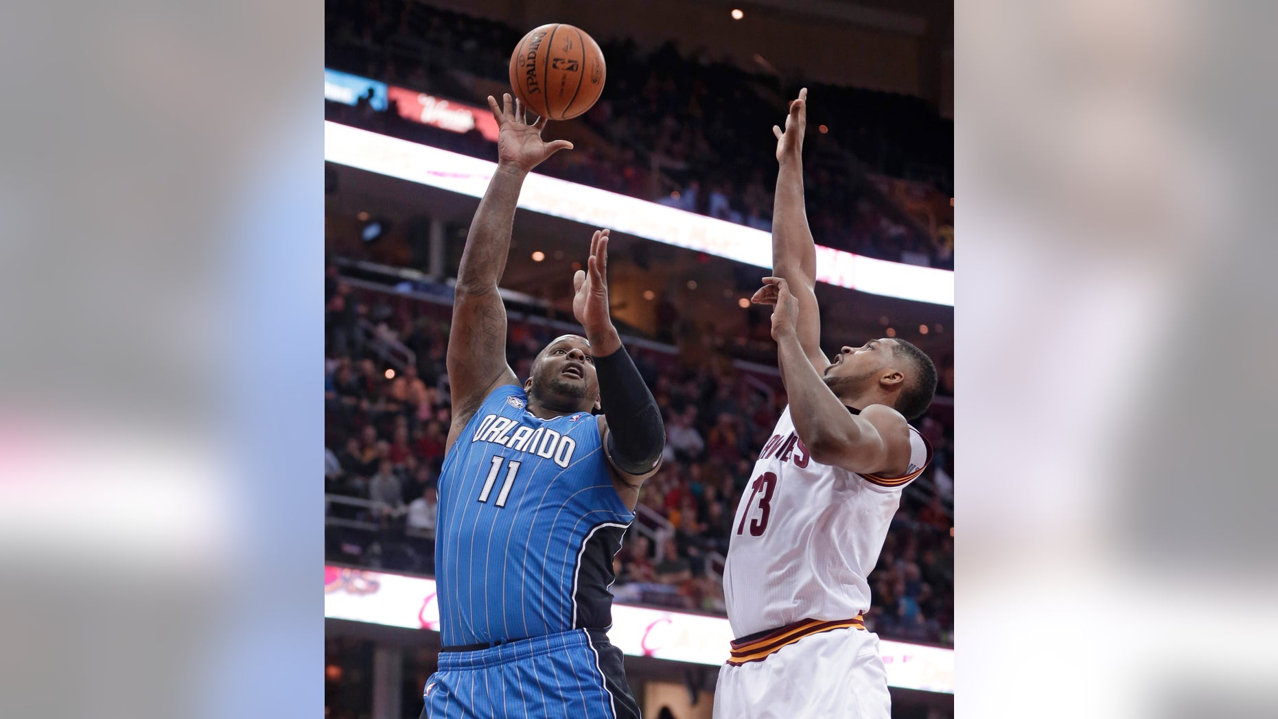 Orlando Magic's Glen Davis (11) shoots over Cleveland Cavaliers' Tristan Thompson (13) during the first quarter of an NBA basketball game Wednesday, Feb. 19, 2014, in Cleveland. (AP Photo/Tony Dejak)