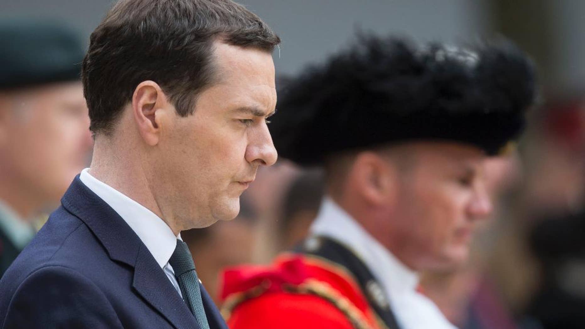 Britain's Chancellor of the Exchequer George Osborne prepares to lay a wealth at the Cenotaph in St Peter's Square, Manchester, England, where a commemoration is being held to mark the 100th anniversary of the start of the World War I battle of the Somme Friday July 1, 2016. Uncertainty about the country's future ties with the EU is weighing heavily on the British economy, prompting Treasury chief George Osborne to announce he was abandoning the government's long-held goal of achieving a budget surplus by 2020. (Danny Lawson/PA via AP)