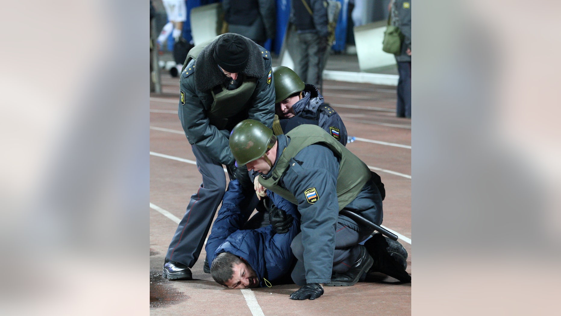 Police detain a soccer fan to stop clashes after a Russia Cup soccer match between Shinnik Yaroslavl and Spartak Moscow at a stadium in Yaroslavl, Russia, Wednesday, Oct. 30, 2013. Police used a water cannon to stop a fight between soccer fans during the match(AP Photo/Alexander Mysyakin)