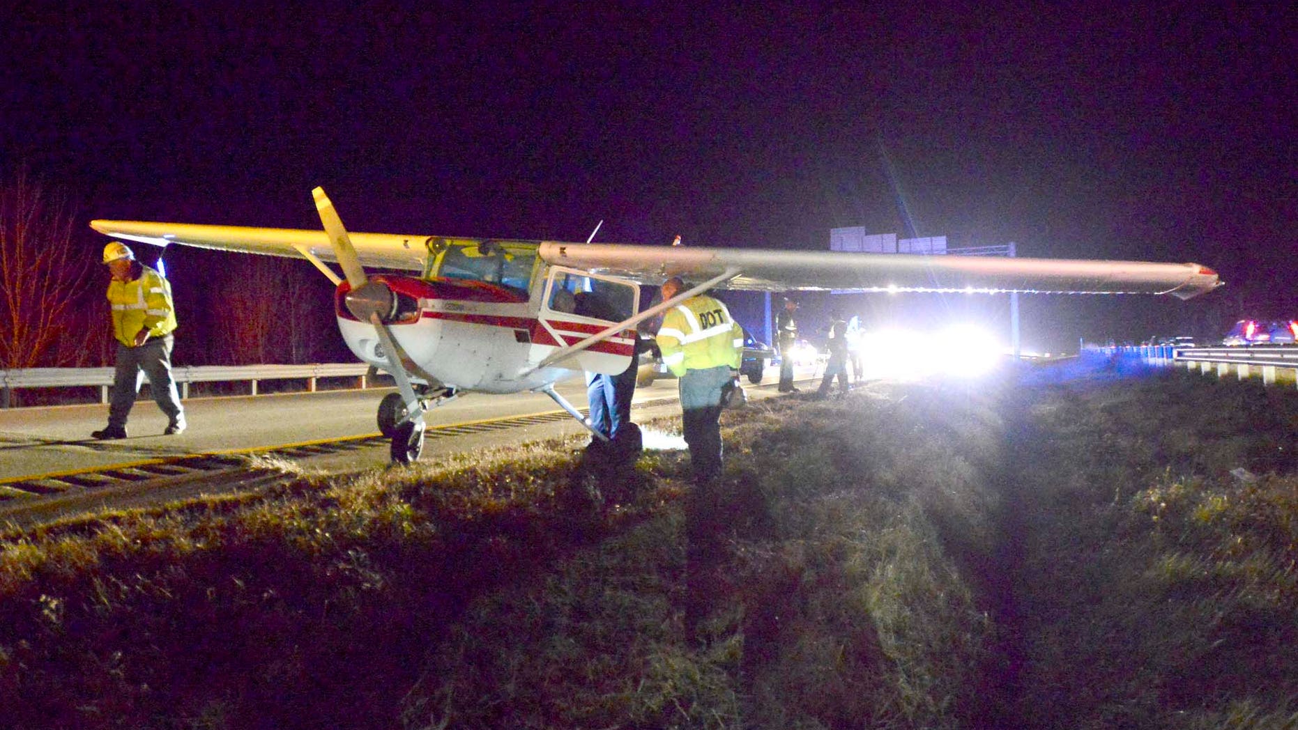 Maine State police and DOT officials look over a small plane that made a emergency landing in the southbound lane of Interstate 295 at mile 13 in Falmouth during evening rush hour traffic on Thursday, Nov. 21, 2013. No injuries were reported. (AP Photo/Portland Press Herald, John Patriquin)