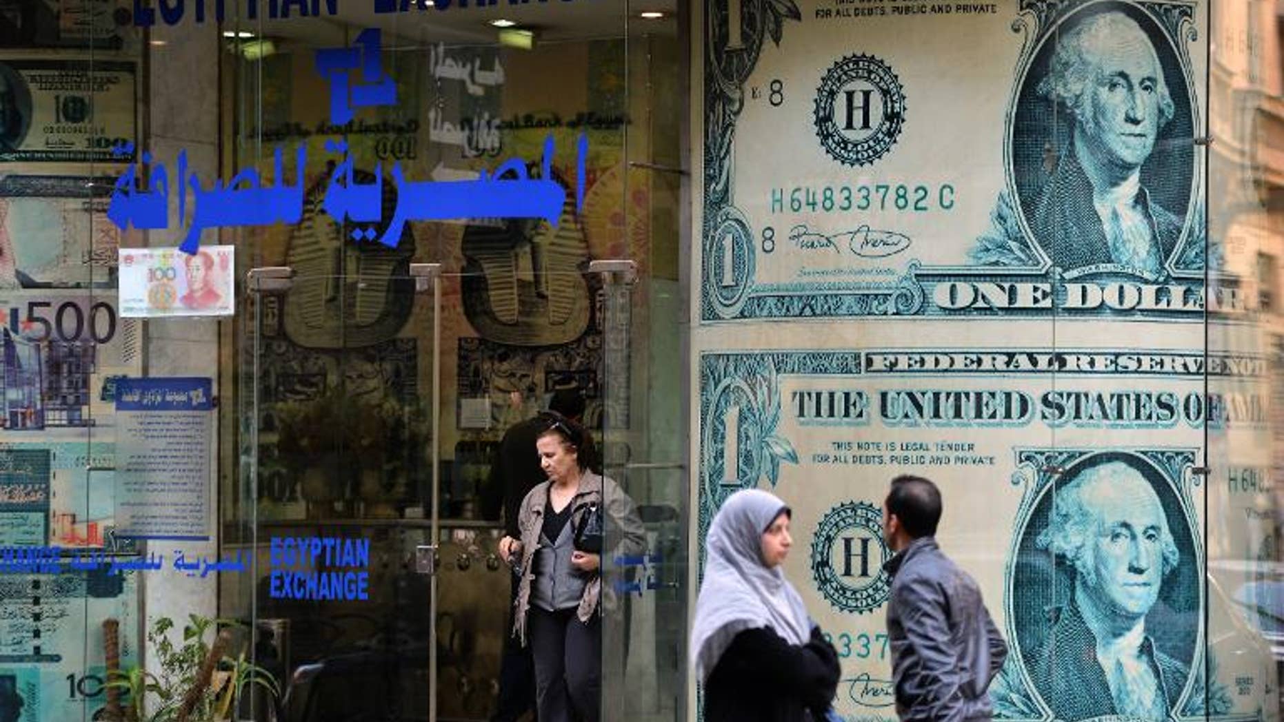 An Egyptian woman exits an foreign currency exchange shop in Cairo on January 6, 2013