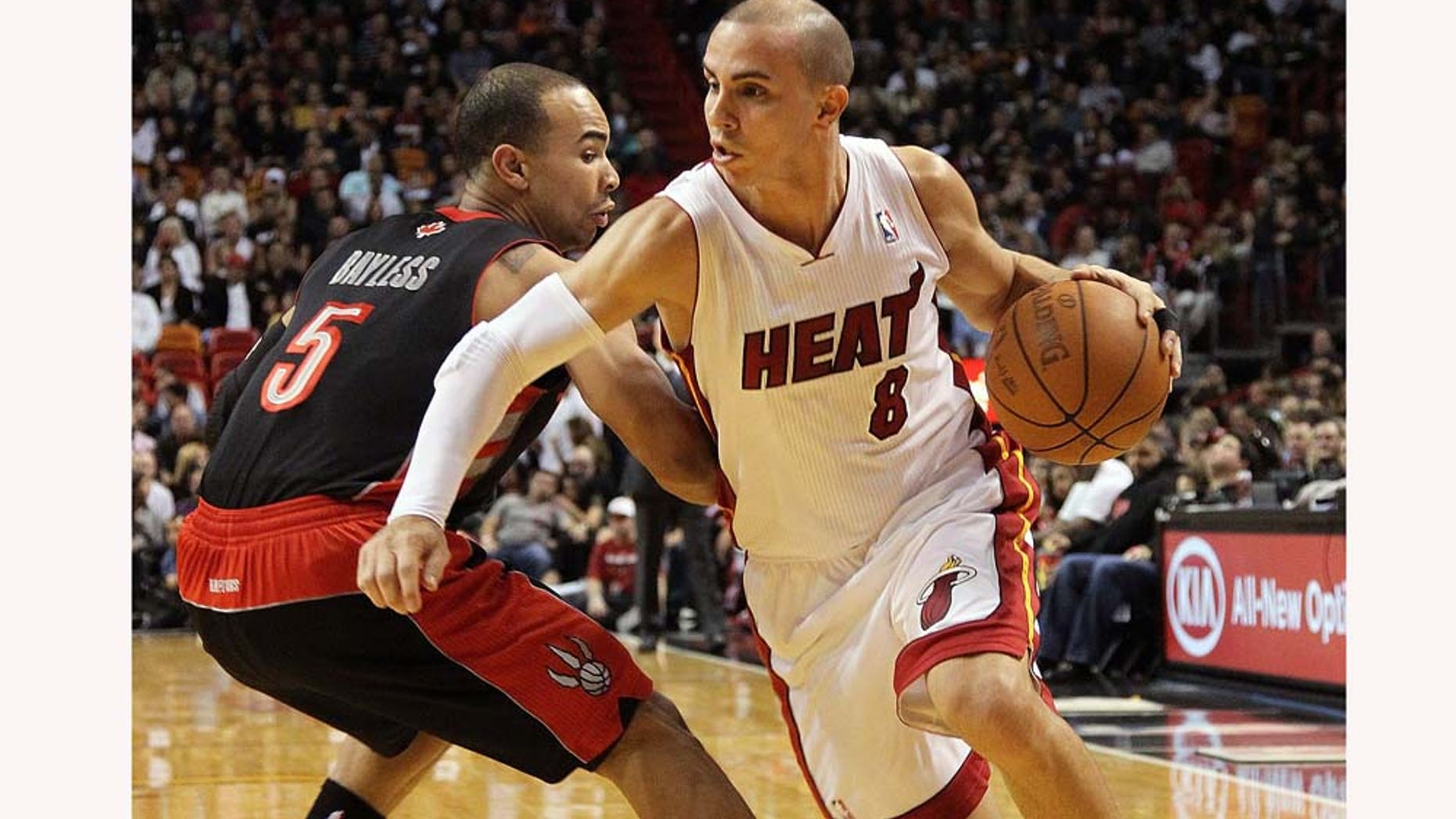 MIAMI, FL - JANUARY 22: Carlos Arroyo #8 of the Miami Heat dribbles by Jerryd Bayless #5 of the Toronto Raptors during a game at American Airlines Arena on January 22, 2011 in Miami, Florida. NOTE TO USER: User expressly acknowledges and agrees that, by downloading and/or using this Photograph, User is consenting to the terms and conditions of the Getty Images License Agreement. (Photo by Mike Ehrmann/Getty Images)