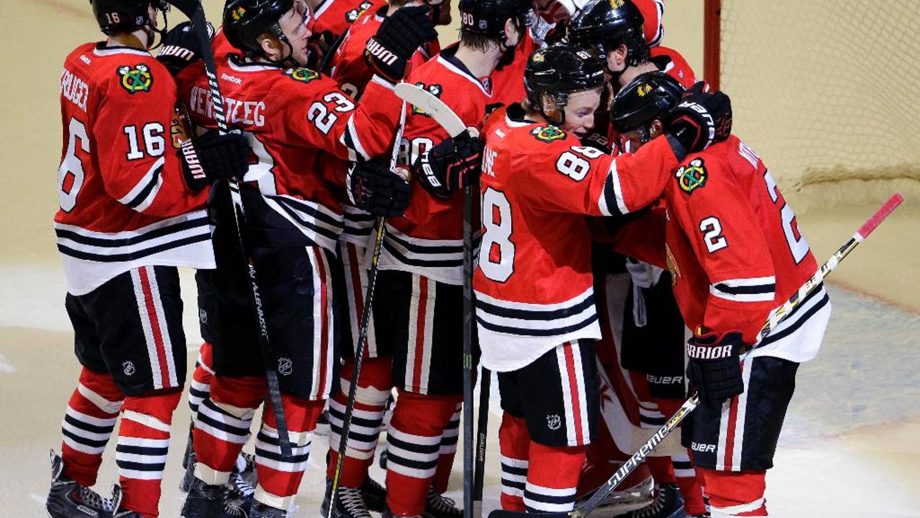 Chicago Blackhawks defenseman Duncan Keith, right, celebrates with teammates after they defeated the Nashville Predators 4-3 in Game 6 of an NHL Western Conference hockey playoff series Saturday, April 25, 2015, in Chicago. (AP Photo/Nam Y. Huh)