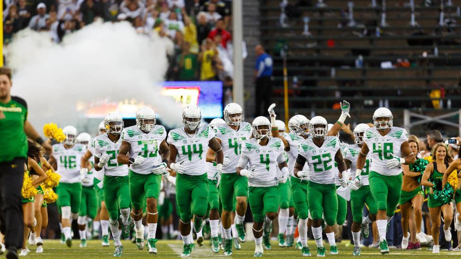 The Oregon football team runs onto the field for an NCAA college football game against South Dakota in Eugene, Ore., Saturday, Aug. 30, 2014. (AP Photo/Ryan Kang)