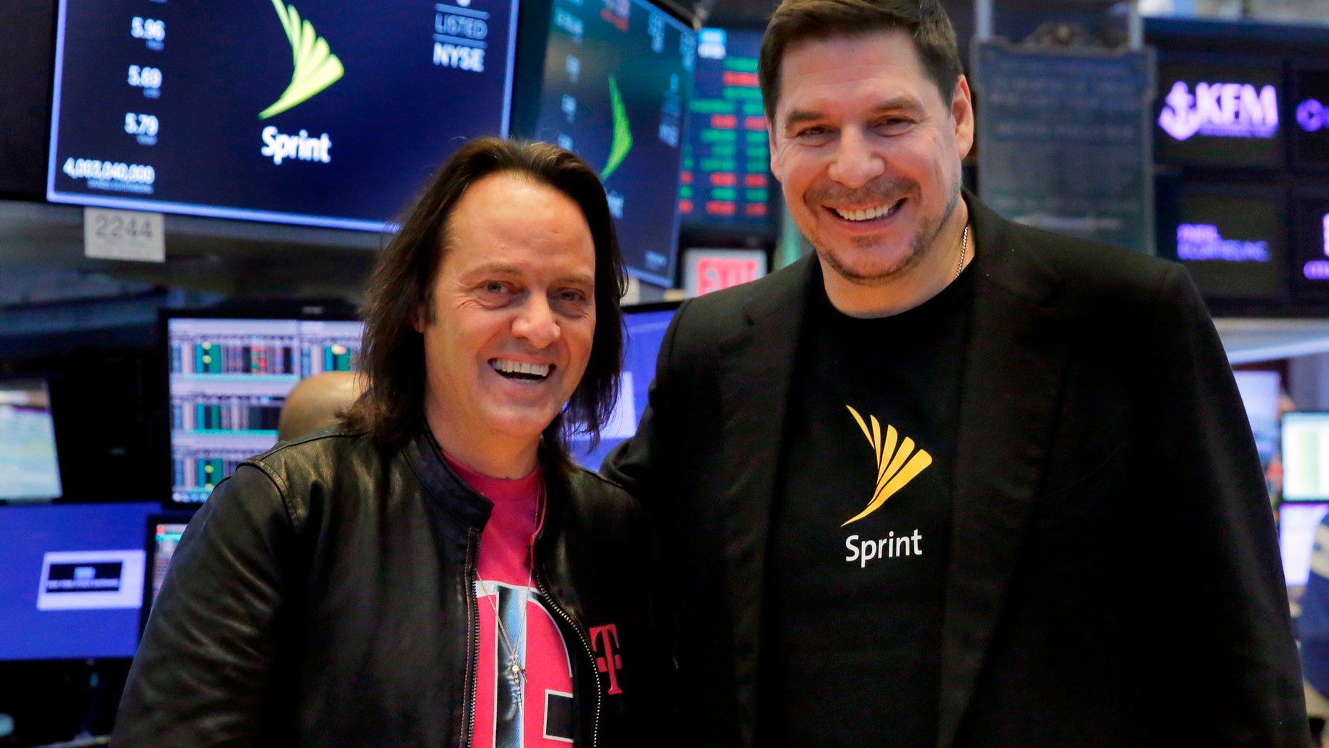 T-Mobile CEO John Legere, left, and Sprint CEO Marcelo Claure pose for photos on the floor of the New York Stock Exchange, Monday, April 30, 2018. To gain approval for their $26.5 billion merger agreement, T-Mobile and Sprint aim to convince antitrust regulators that there is plenty of competition for wireless service beyond Verizon and AT&T. (AP Photo/Richard Drew)