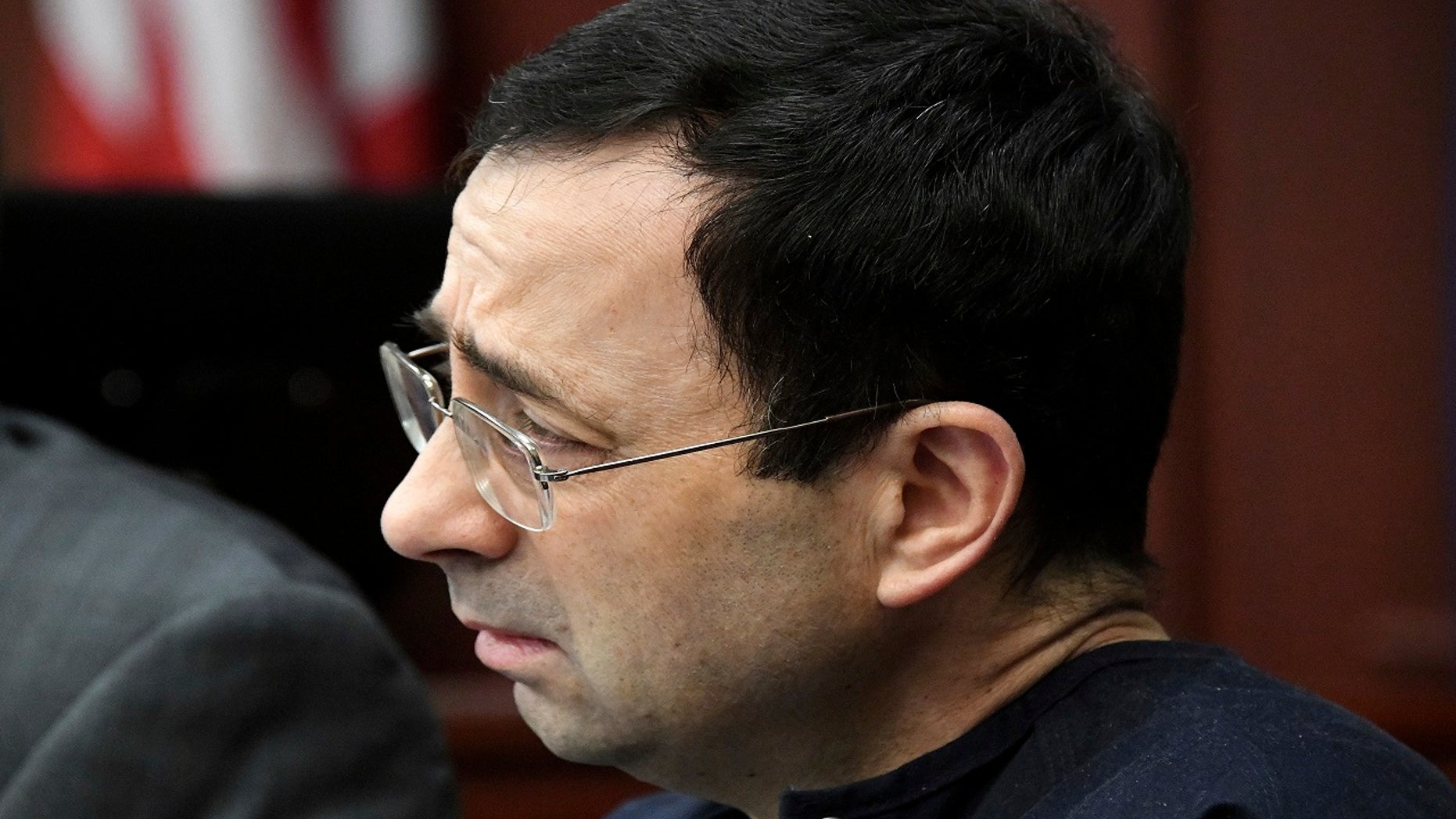Larry Nassar listens to Jordyn Wieber's impact statement in the court of Judge Rosemarie Aquilina, Jan. 19, 2018, in Lansing, Mich., during the fourth day of sentencing for the former sports doctor, who pled guilty to multiple counts of sexual assault.