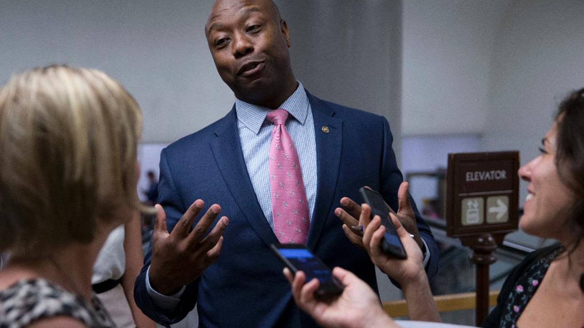 FILE - In this June 21, 2016, file photo, Sen. Tim Scott, R-S.C., talks with reporters on Capitol Hill in Washington. Scott candidly described being stopped by police and Capitol Hill cops because of the color of his skin. It's an experience all too familiar to many of his African-American colleagues in Congress. A day after Scott’s personal recounting on the Senate floor, several lawmakers said July 14, that they have had similar experiences. (AP Photo/Alex Brandon, File)