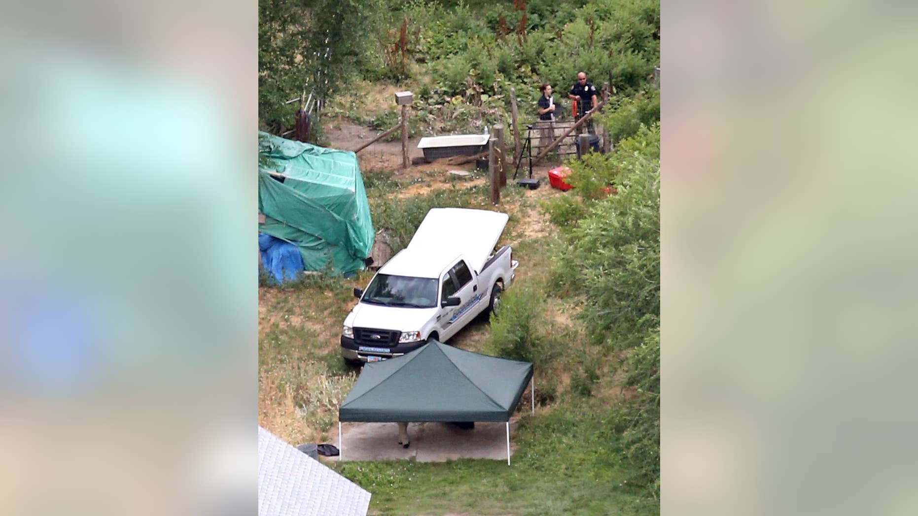 In this aerial photo, investigators look for evidence in the field where the body of a 12-year-old girl found on Friday , July 17, 2015, in West Valley City, Utah. West Valley City Police Chief Lee Russo said Friday the girl left her house about midnight with someone her parents didn't know. Police believe she was killed in an altercation in the field near where her body was found in the suburb of Salt Lake City.(Tom Smart/The Deseret News via AP) SALT LAKE TRIBUNE OUT; MAGS OUT; MANDATORY CREDIT